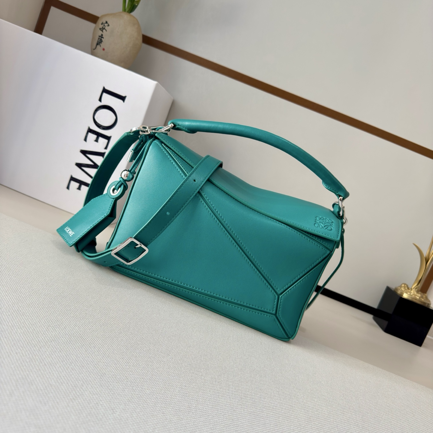 NO:343113,LOw new small Napa sheep leather Featherlight Puzzle handbag outlines rectangular shape with unique geometric lines. Soft and light Napa leather injects casual and lazy style into the handbag. It can be shoulder, crossbody or carry. Removable adjustable shoulder straps with rotary snap zipper opening and closure, articulated zipper head One external zipper rear pocket, one internal insert bag * removable LOE**WE gold or silver label with secret pocket and balloon dice* rectangular metal foot nails Napa sheep leather lining Anagram embossed, decorative internal engraving LOE**WE. Model 062502 size: 24*10.5*16.5cm (with full package), new sheepskin geometric bag, loewe, sheepskin19860909LOw新款 小号纳帕羊皮革 Featherlight Puzzle 手袋 以别具一格的几何线条勾勒长方体造型.柔软轻盈的纳帕皮革为手袋注入随性慵懒的风格.可肩背、斜挎或手提 可拆卸可调节肩带,饰有旋转卡扣*拉链开合,铰接式拉链头 一个外部拉链后袋,一个内部插袋*可拆卸 LOE**WE 烫金或烫银标签,饰有隐秘口袋和气球骰子*长方形金属脚钉 纳帕羊皮革衬里 Anagram 压纹、饰牌内部镌刻 LOE**WE. 型号062502 size:24*10.5*16.5cm（配全套包装）,羊皮新款几何包,loewe,sheepskin,Bag