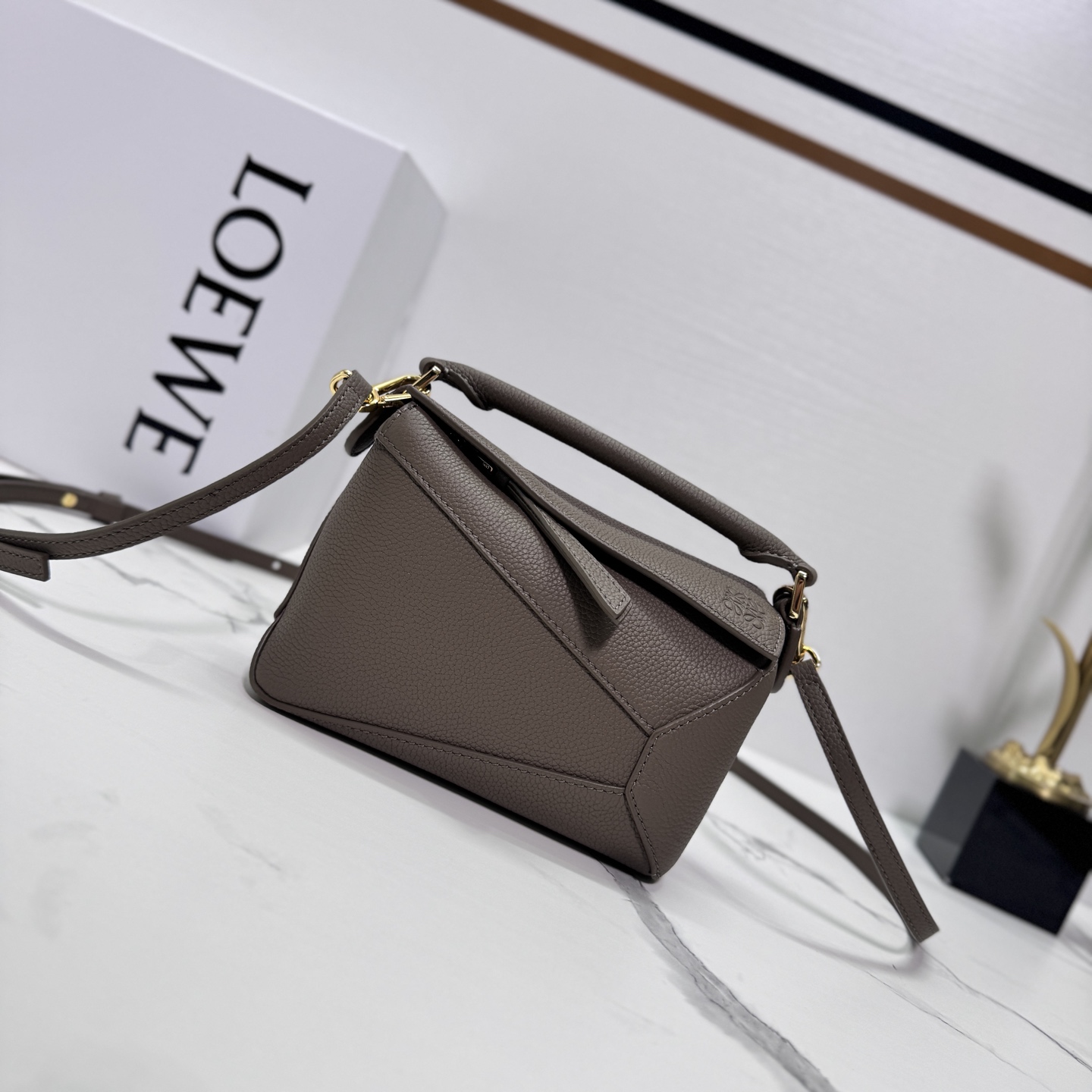 NO:342714,Lw New Version Soft Grain Cowhide Leather Puzzle Edge Handbag Home debuts tote bag* rectangular shape and precise cutting technology creates Puzzle’s unique geometric lines* This mini version is made of soft grain cowhide leather with overlapping edges. Mini Puzzle can hold for example a small vertical wallet, most sizes of phones (up to 6.1 inches) and sunglasses, shoulder or crossbody* hand hold or top handle carrying* adjustable shoulder straps, removable* an internal insertion pocket and an external rear zipper pocket* a zipper closure with cowhide leather zipper head* herringbone cotton canvas lining Anagram embossed size: 18*12.5*8CＭ Model 062312 (with full package), new Puzzle  Edge (mini), wallets, cowhide19860909Lw新版本 柔软粒面牛皮革Puzzle Edge手袋 家推出的首次亮相手提包*长方体形状和精确的切割技术创造了 Puzzle 独特的几何线条*这个迷你版本采用柔软粒面牛皮革制成,饰有重叠边缘.迷你Puzzle可以容纳例如一只小号垂直钱包,大多数尺寸的手机（最大6.1寸）和太阳镜,肩背或斜挎*手拿或顶部提手携带*肩带可调节,可拆卸*一个内部插袋和一个外部后方拉链口袋*拉链开合带牛皮革拉链头*人字纹棉质帆布衬里Anagram 压纹 size:18*12.5*8CＭ 型号062312（配全套包装）,新款Puzzle Edge（迷你）,wallets,cowhide,Bag