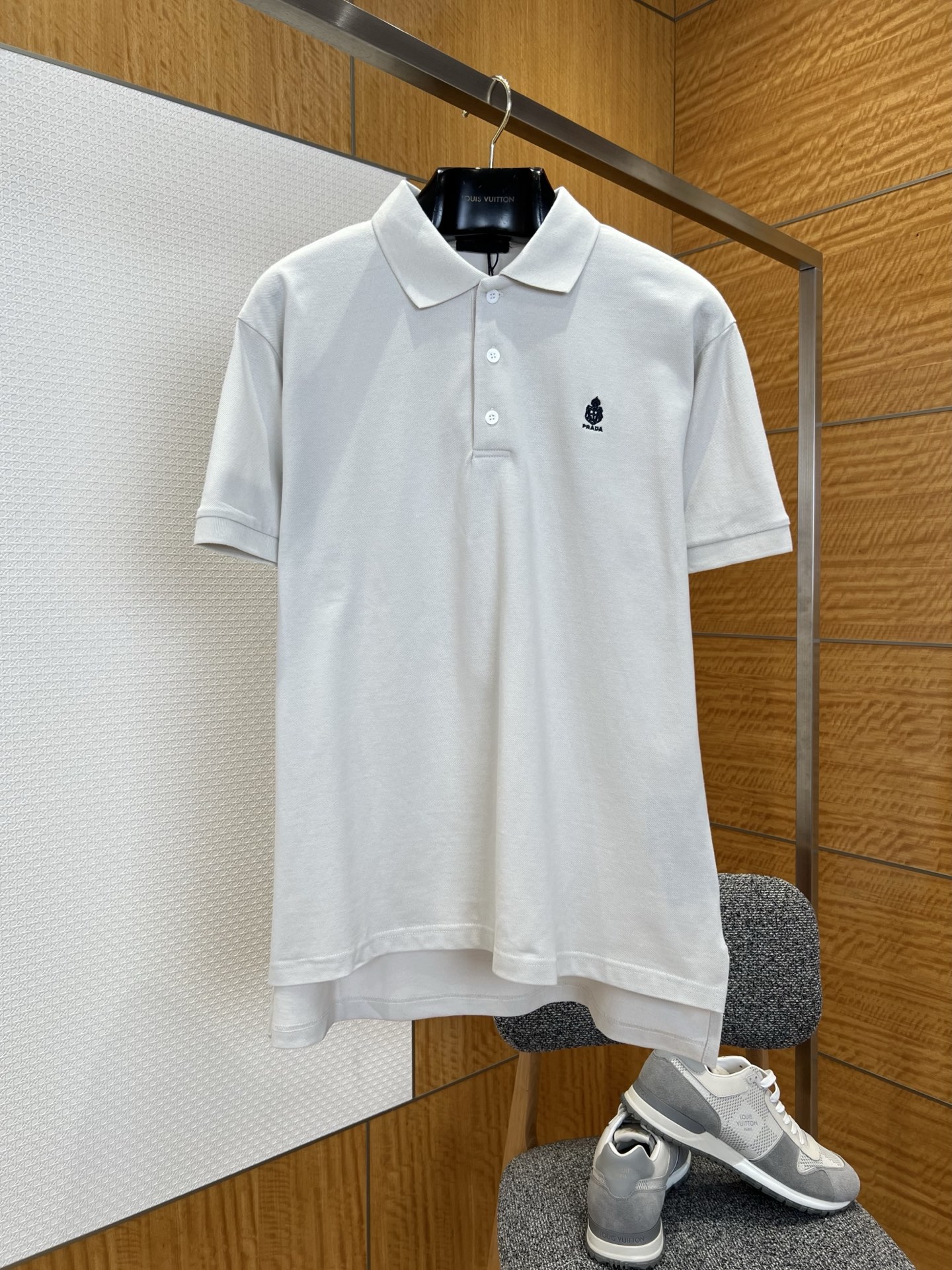 NO:827823,PRA classic embroidered logo short-sleeved polo shirt ——————  It is made of high-count combed pique cotton fabric and has been polished through multiple processes to present a fine and full honeycomb texture. It feels dry and skin-friendly. It has excellent moisture absorption and perspiration performance and stiffness and anti-wrinkle properties. The upper body is breathable and not sweaty, and it is not easy to collapse and deform after long-term wear.  , always maintain a neat silhouette; the neckline adopts a classic lapel design, and the collar shape has been treated with three-dimensional shaping technology, which is not easy to curl and deform. The collar edge is smooth and firm, and the details are exquisite; the left chest is decorated with the brand's iconic logo embroidery, which is made of high  Made with dense embroidery thread technology, the stitches are fine and neat, the pattern lines are clear and three-dimensional, and the brand recognition is low-key; the cuffs are made of flat seaming technology, the lines are even and smooth, and the hem is slightly curved and short in the front and long in the back, which optimizes the wearing experience and has clever details; the overall fit is neat and neat, modifying the body shape while retaining comfortable space for movement. Whether it is worn with casual pants for daily commuting or with trousers for light business occasions, it can be easily controlled, perfectly interpreting the brand's simple and advanced design aesthetics.  ————————8888 Material: Cotton Fitted Color Off-white Size S/M/L/XL, Prada-clothing, prada, prada, T-shirt,19860909PRA 经典刺绣徽标短袖Polo衫 —————— 采用高支精梳珠地棉面料,经过多道工艺打磨,呈现出细腻饱满的蜂窝状肌理,触感干爽亲肤,兼具优异的吸湿排汗性能与挺括抗皱性,上身透气不闷汗,久穿不易软塌变形,始终保持利落版型；领口采用经典翻领设计,领型经过立体定型工艺处理,不易卷边变形,领边走线平整牢固,细节处尽显精致；左胸位置饰有品牌标志性徽标刺绣,采用高密绣线工艺打造,针脚细密工整,图案线条清晰立体,低调彰显品牌辨识度；袖口采用平整锁边工艺,走线均匀流畅,下摆采用前短后长的微弧形剪裁,优化穿着体验,兼具细节巧思；整体版型合身利落,修饰身形的同时保留舒适活动空间,无论是日常通勤搭配休闲裤,还是轻商务场合搭配西裤,都能轻松驾驭,完美诠释品牌简约高级的设计美学. ————————8888 材质: 棉 版型合身 颜色米白色 尺码S/M/L/XL,普拉达-服装,prada,prada,T-shirt,,Women's clothing