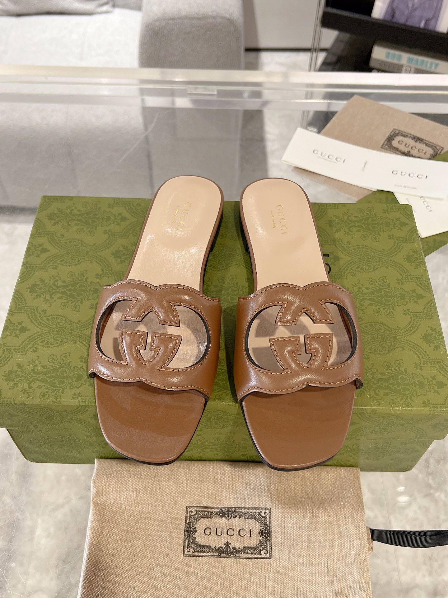 NO:168582,Women's interlocking double G hollow details slippers The collection design of the 1970s injects glory into the brand. Taking inspiration from this iconic era, the interlocking double G is rejuvenated into large-sized hollow details on this white leather slipper. The 