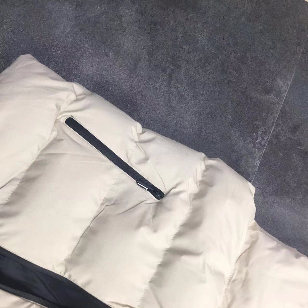 供货价:55💰『官网羽绒棉马甲』百搭不腻版,满足各种身材中空棉,原包装+原吊牌 ,UA安德玛秋冬季立领情侣蓬松棉马甲 外套
经典著作，日常休闲 随意搭配 都是无可挑剔，送人自留！都非常有面A9901
        经典款式 百搭而不会过时，款型简约而不简单，对于各种年龄段男士都能接受。立体修身裁剪，版型更加复合国人身材标准，
精湛工艺打造，走线平稳整齐版本，为凸显上身立体效果，采用V字型绗缝?直线绗缝，胸前印染LOGO，反光 醒目不张扬，低调有格调。
     采优填充 非常严格筛选加工的，蓬松度也非常好！一分不多一分不少！上身有型！不会显得臃肿。两侧口袋拉链闭合 门禁拉链 上身舒适度超高！
面料：绵纶  防水
颜色:  黑色  米色 版型偏小码看尺寸选号
尺码：L~5xl