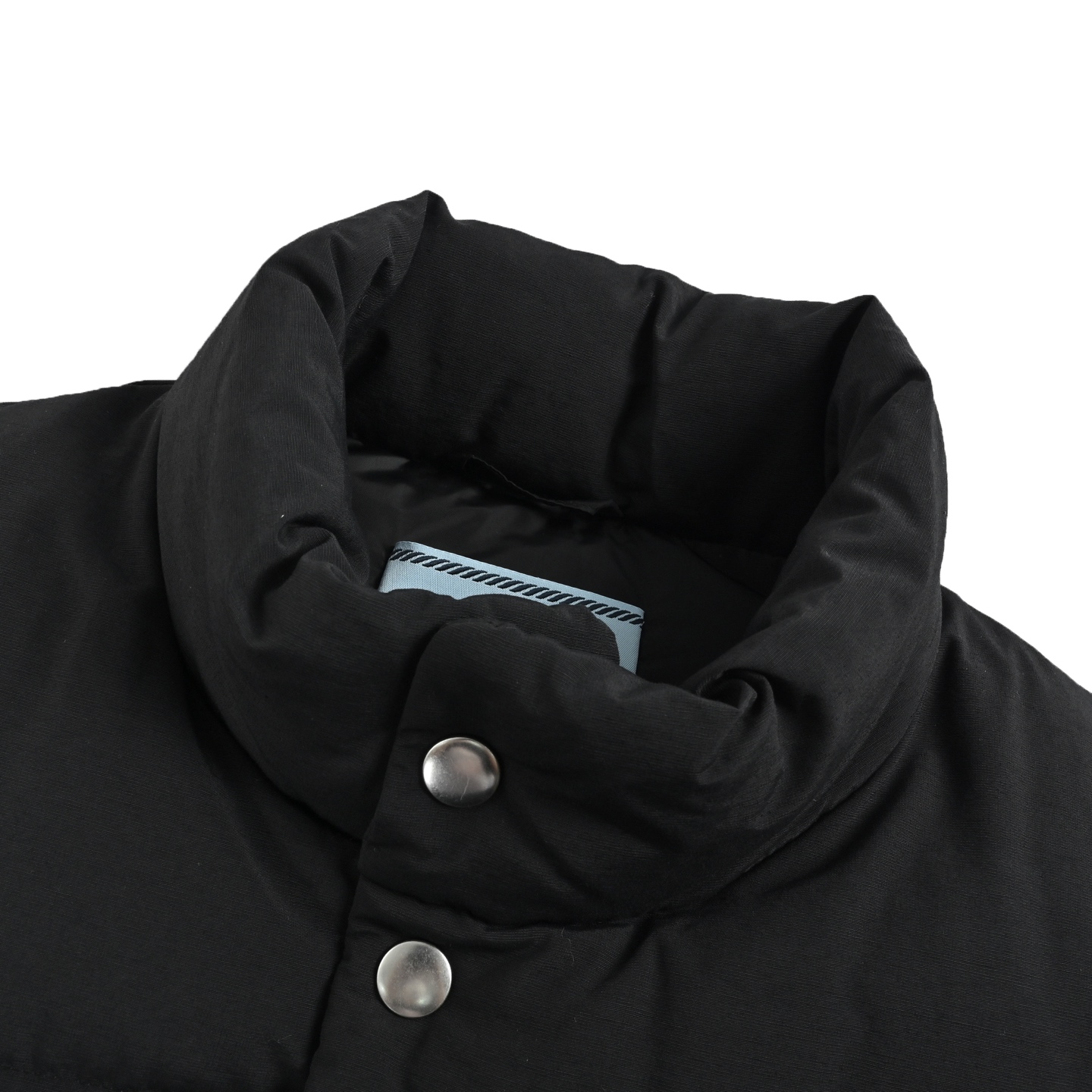 本地自取:  💰450
Prada/普拉达 三角标双口袋羽绒马甲
面料采用55%棉与45%再生锦纶混纺，融合自然质感与环保理念，内衬细腻亲肤，适合长时间穿着，采用90新国标白鸭绒细腻填充工艺，温暖却不臃肿。两个翻盖贴袋兼顾实用与造型感，拉链与按扣双开合赋予穿脱更多自由。下摆弹力抽绳巧妙收束，勾勒利落身形，无论是搭配衬衫打造商务休闲风，还是结合卫衣演绎街头感，皆游刃有余。内里带衬设计亲肤舒适，涂抹金属徽标如暗夜星光般点睛。从城市通勤到周末远足，它既是功能主义的化身，亦是风格宣言的载体。
Size:S-XL