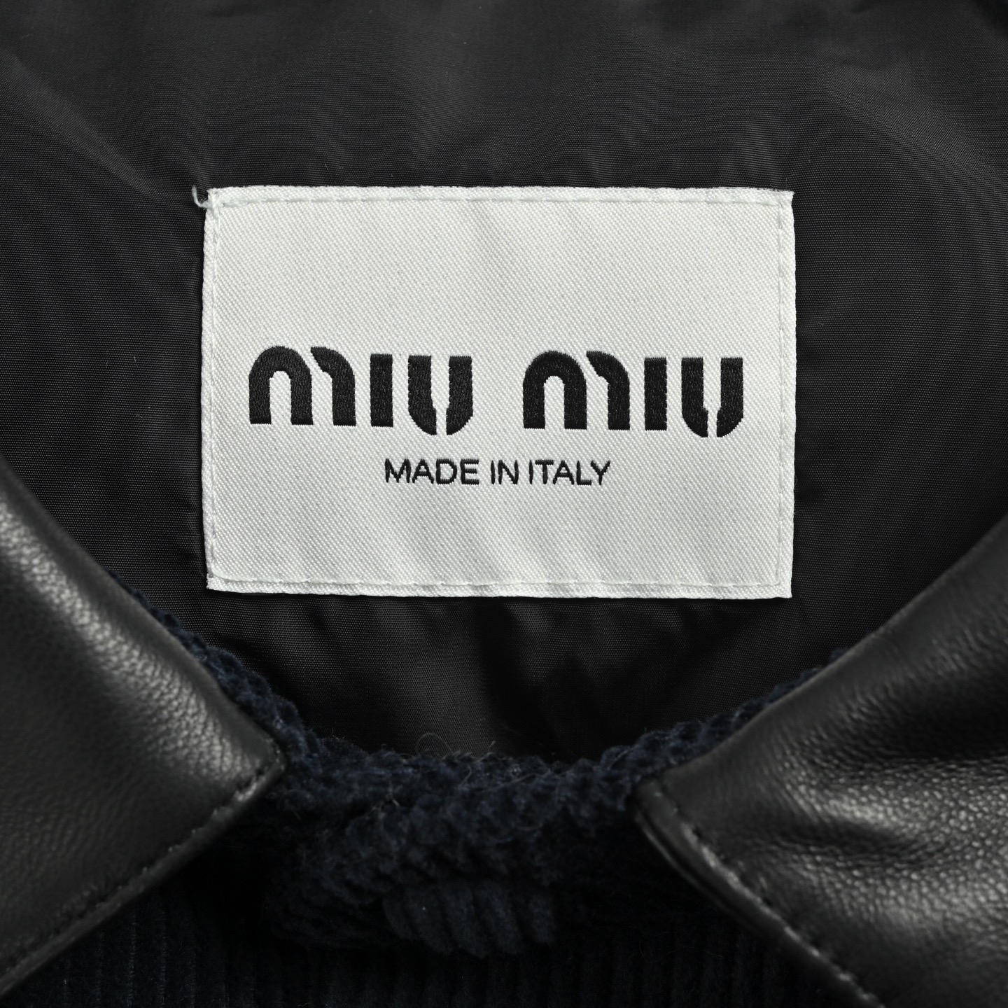 本地自取:💰530
Miu Miu/缪缪 皮领灯芯绒羽绒服
经典细棱灯芯绒包裹身躯,羽绒如云朵潜伏于凹凸经纬之间。90%白鸭绒无声抵御寒风,却让面料自己说话——每一道绒沟都是日光走过的轨迹,每一条棱线都是温暖筑起的堡垒。
定制的小羊皮翻领沿颈项曲线降落,如第二层肌肤般贴合呼吸。冷冽皮革与柔软绒面在领口完成一场材质博弈,金属按扣开合声成为这场对话里唯一的标点符号。
精致的贴布绣工艺在左胸口袋上演视觉魔法:字母绣花贴饰经激光切割定型工艺打造浮雕质感,字体清晰。每片贴饰经过5道抗皱处理,确保水洗后仍保持原有形态。与面料完全同色的绣布沿MIUMIU标识游走,仅以微妙的光泽差与针脚凸起强化视觉辨识度
Size:46 48 50 52