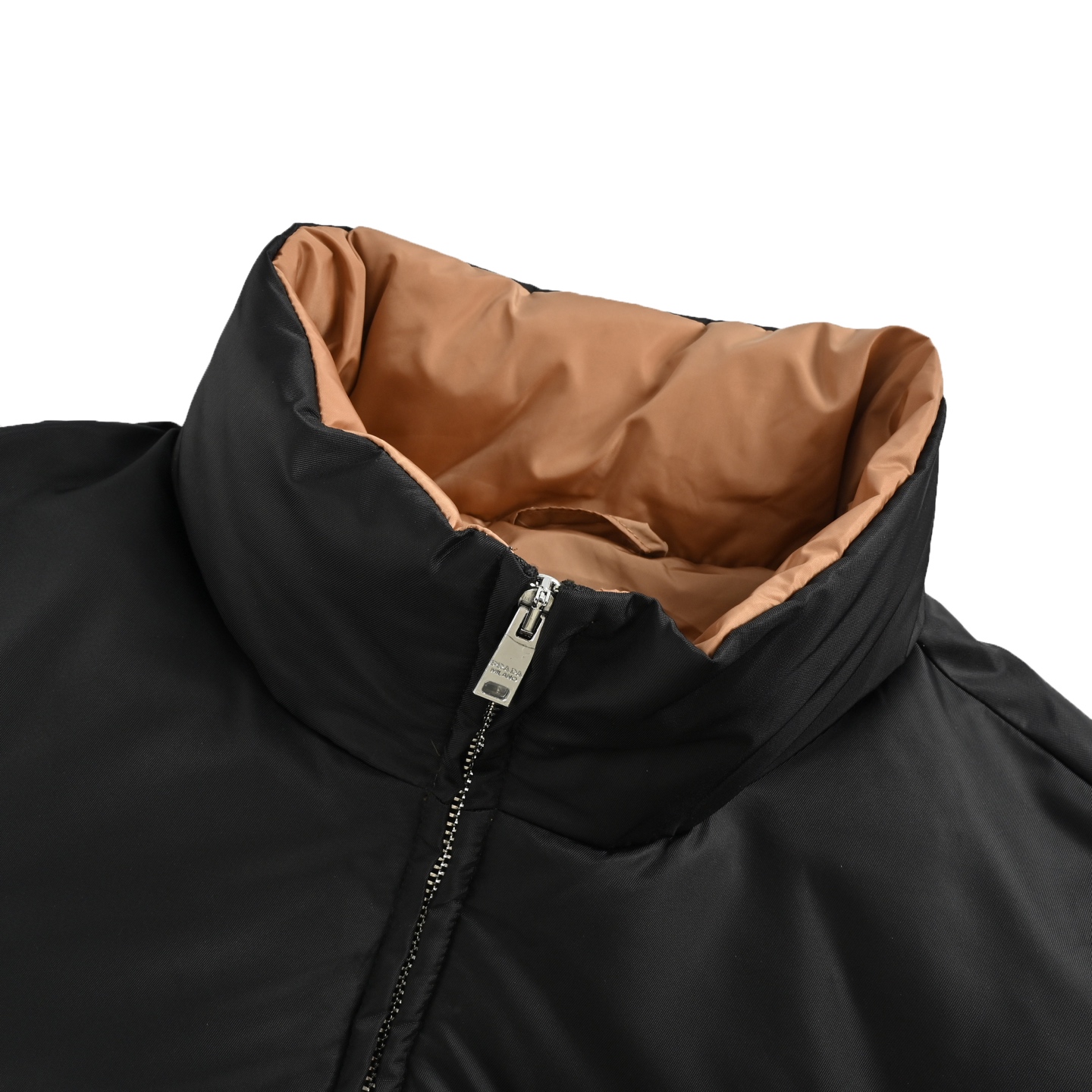 本地自取: 💰550
Prada/普拉达 尼龙拉链口袋撞色立领羽绒服
选用100%锦纶制成的再生尼龙面料,通过先进的纺织技术,编织成紧密且坚韧的布料,提升骨架强度有效阻挡冷风侵袭,锁住羽绒层产生的暖空气,经过紧密的编织工艺和特殊处理之后使其具备防水防风等功能,表面形成一定的荷叶效应,同时抗皱不易变形,易于日常打理。
内衬采用了100%聚酰胺编织而成的焦糖棕色尼龙面料,翻折时形成强烈色彩对冲,宛如将落日熔金注入深邃夜空。聚酰胺纤维以其极高的强度与卓越的亲肤感著称,触感如丝般顺滑,避免了穿着厚重内衣时可能产生的摩擦不适。它与外层尼龙协同工作,共同构建了一个透气、锁温、且极度舒适的微气候环境,让温暖呵护时刻在线,却毫无闷热与束缚感
选用90白鸭绒,蓬松度达220g,确保保暖性能卓越。绒子经过严格筛选与处理之后,不易钻绒。6公分加高立领剪裁,贴合颈部线条却不压迫,,寒风中宛如“第二层肌肤”般温暖。领口与拉链衔接处采用斜角拼接工艺,避免传统立领的呆板感,转头时更显灵动。下摆内置双侧金属调节扣,轻轻下拉即可收紧腰线,上提则恢复宽松廓形——通勤时利落修身,户外时自由无拘。调节扣金属表面经PVD镀层处理,耐磨抗腐蚀,历久弥新。
采用电脑绗缝机,将面料分割为8个独立绒格,针距严格控制在3针/cm,线迹误差不超过0.1mm,缝线选用高强度尼龙线,拉力测试达20N(约2kg承重),杜绝因缝线断裂导致的钻绒问题。
Size:S-XL