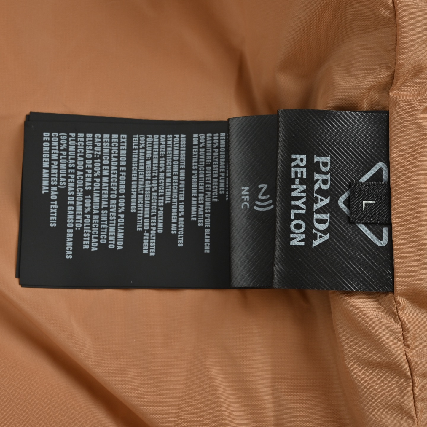 本地自取: 💰550
Prada/普拉达 尼龙拉链口袋撞色立领羽绒服
选用100%锦纶制成的再生尼龙面料,通过先进的纺织技术,编织成紧密且坚韧的布料,提升骨架强度有效阻挡冷风侵袭,锁住羽绒层产生的暖空气,经过紧密的编织工艺和特殊处理之后使其具备防水防风等功能,表面形成一定的荷叶效应,同时抗皱不易变形,易于日常打理。
内衬采用了100%聚酰胺编织而成的焦糖棕色尼龙面料,翻折时形成强烈色彩对冲,宛如将落日熔金注入深邃夜空。聚酰胺纤维以其极高的强度与卓越的亲肤感著称,触感如丝般顺滑,避免了穿着厚重内衣时可能产生的摩擦不适。它与外层尼龙协同工作,共同构建了一个透气、锁温、且极度舒适的微气候环境,让温暖呵护时刻在线,却毫无闷热与束缚感
选用90白鸭绒,蓬松度达220g,确保保暖性能卓越。绒子经过严格筛选与处理之后,不易钻绒。6公分加高立领剪裁,贴合颈部线条却不压迫,,寒风中宛如“第二层肌肤”般温暖。领口与拉链衔接处采用斜角拼接工艺,避免传统立领的呆板感,转头时更显灵动。下摆内置双侧金属调节扣,轻轻下拉即可收紧腰线,上提则恢复宽松廓形——通勤时利落修身,户外时自由无拘。调节扣金属表面经PVD镀层处理,耐磨抗腐蚀,历久弥新。
采用电脑绗缝机,将面料分割为8个独立绒格,针距严格控制在3针/cm,线迹误差不超过0.1mm,缝线选用高强度尼龙线,拉力测试达20N(约2kg承重),杜绝因缝线断裂导致的钻绒问题。
Size:S-XL