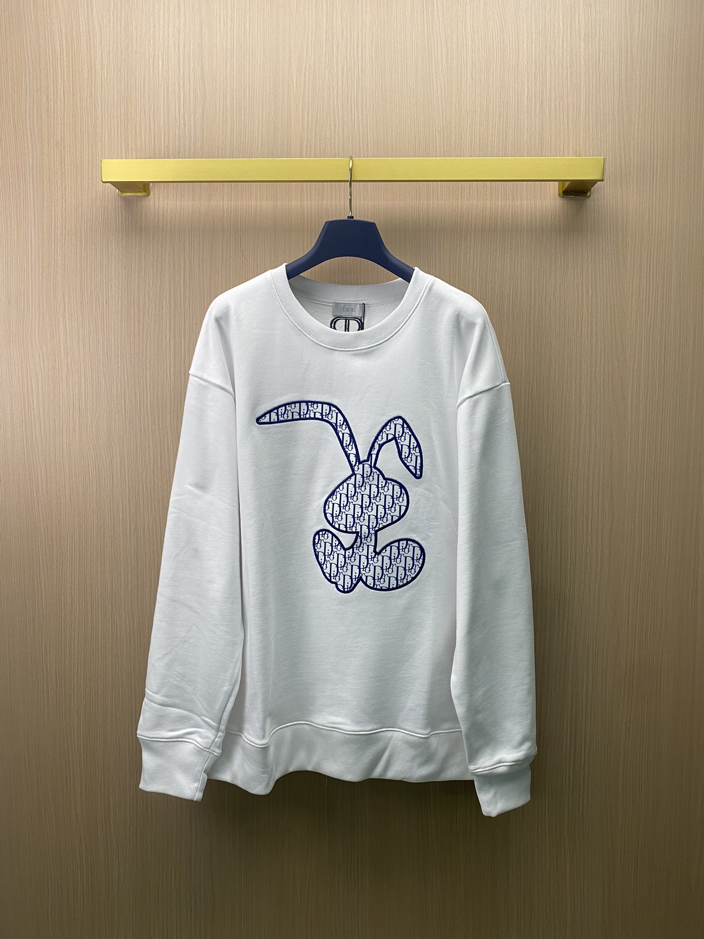 La nueva sudadera de Dior con cuello redondo, parches bordados y estampado de conejos para parejas. La tela está impres…