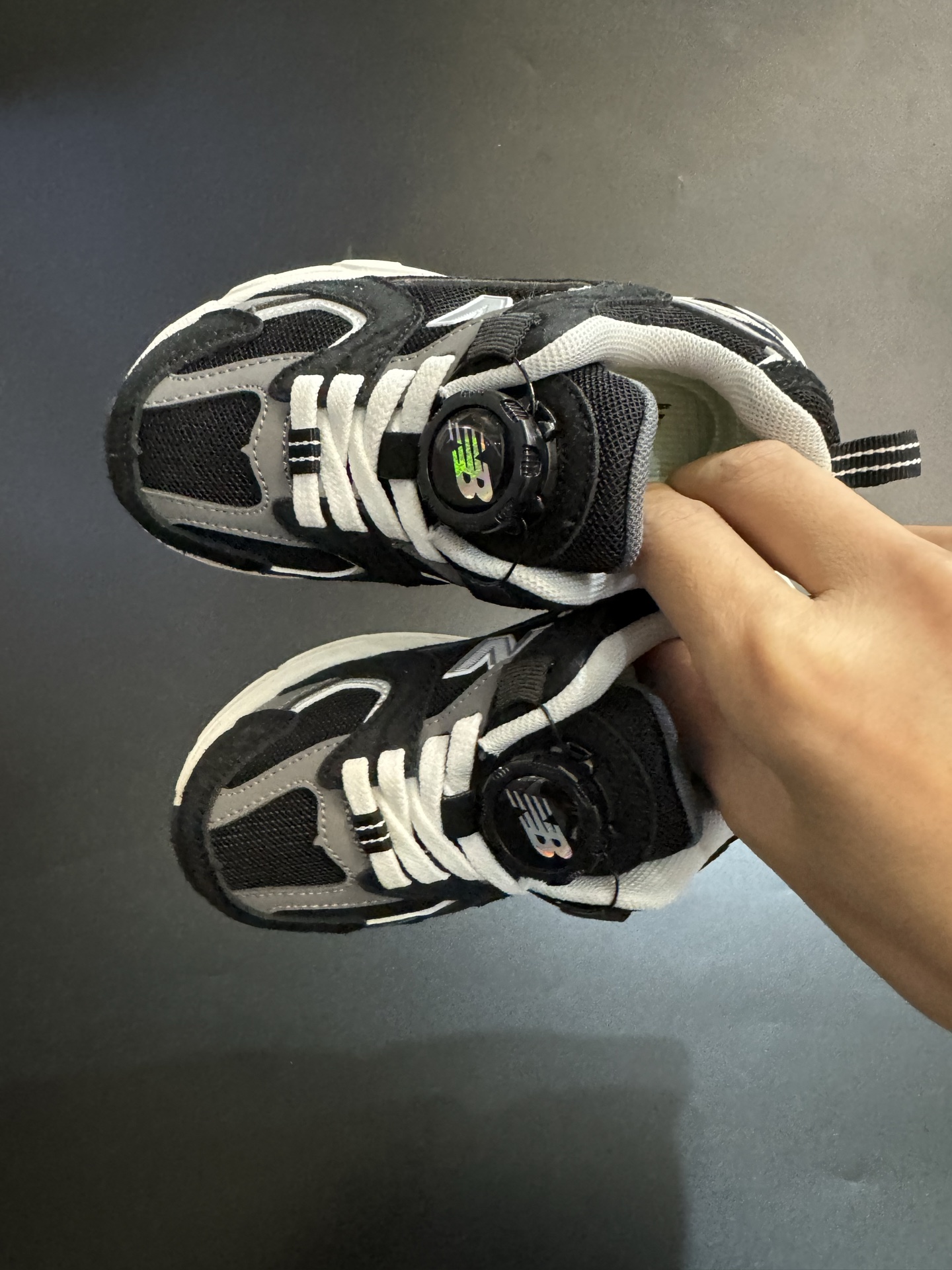 NB530旋转纽扣童鞋透气舒适运动鞋 尺码：26-37码 🌈对于许多家长来说，找到既美观又实用的儿童鞋是件棘手的事。但当谈到NB530旋转纽扣童鞋时，一切问题迎刃而解！这些鞋子不仅让宝宝们看起来更加可爱，而且穿脱也变得极其简单。🚀 🎈 旋转纽扣的设计不仅时尚，还非常便于小朋友们自己穿鞋。同时也减轻了父母每天早上匆忙帮孩子穿衣的压力。🌟 🌿 这些鞋子采用环保材料制成，对宝宝娇嫩的脚丫十分友好。柔软且透气的内里设计，保证了即使在炎炎夏日，宝宝也能感受到舒适。🌞 🎉 最重要的是，NB530童鞋的外观设计既简约又不失时尚感，无论是去公园玩耍还是参加家庭聚会，都是完美的选择。🎈-选品中心