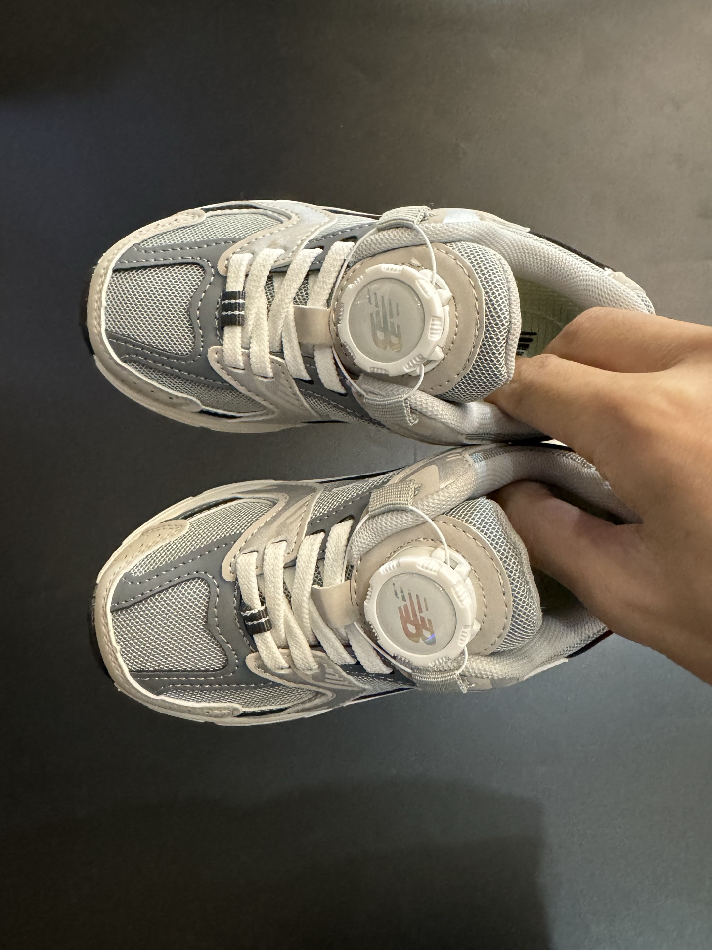 NB530旋转纽扣童鞋透气舒适运动鞋 尺码：26-37码 🌈对于许多家长来说，找到既美观又实用的儿童鞋是件棘手的事。但当谈到NB530旋转纽扣童鞋时，一切问题迎刃而解！这些鞋子不仅让宝宝们看起来更加可爱，而且穿脱也变得极其简单。🚀 🎈 旋转纽扣的设计不仅时尚，还非常便于小朋友们自己穿鞋。同时也减轻了父母每天早上匆忙帮孩子穿衣的压力。🌟 🌿 这些鞋子采用环保材料制成，对宝宝娇嫩的脚丫十分友好。柔软且透气的内里设计，保证了即使在炎炎夏日，宝宝也能感受到舒适。🌞 🎉 最重要的是，NB530童鞋的外观设计既简约又不失时尚感，无论是去公园玩耍还是参加家庭聚会，都是完美的选择。🎈-选品中心