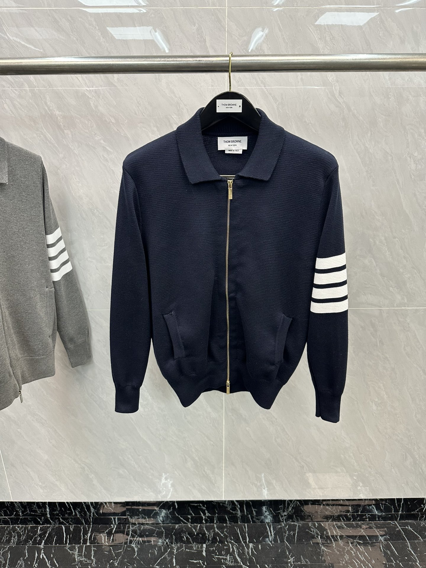 💰280 THOM BROWNE四杠翻领拉链针织衫
料子采用羊毛混纺  拉链采用TB四道杠拉链头
柔软舒适 生产采用日本进口自动针织机织造  
针路紧密 袖子条纹针织而成 
版型可修身可宽松 舒适透气 
男女同款
三标齐 包装吊牌齐全 
可加全套礼盒包装
颜色：灰色/藏青
尺码：1/2/3/4