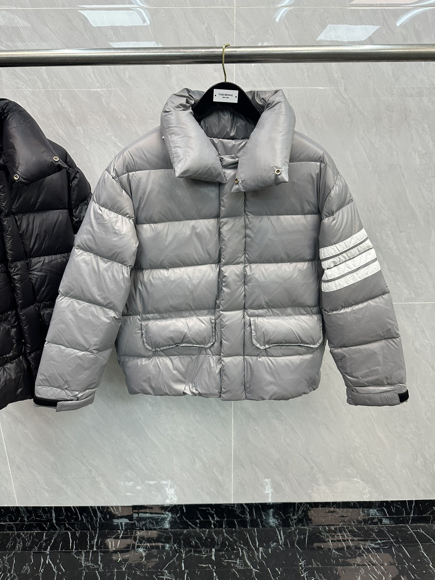💰445 THOMBROWNE汤姆布朗经典四条杠情侣羽绒面包服
最完美的情侣款这件面包服出镜率真的很高好几次的机场街拍都少不了它的陪伴又美又暖，不穿它穿谁!选用400T高密度防风抗寒功能性面料，手感柔软舒适经典的三色条纹内里，如丝绸一般顺滑且具有超强的抗静电抗皱能力在原材料方面，羽绒服的核心就在于里面的绒的品质内里是90%国标鸭绒填充简直不要太轻盈保暖!隔绝外界冷空气的入侵!!工艺更是精湛，严防钻绒，真空充绒!采用国际先进的真空充绒技术，增加空气隔层不损伤羽线，能保持羽原有的柔软性、弹性及手感将羽绒的保暖性发挥到佳!版型设计更是相当时髦，本身是简约纯色，衣身虽然没有品牌logo但胸前 TB标志性的四杠袖已经透露着高端的气息!搭配卫衣或衬衣，保暖又够潮让你轻松成为最时尚个性的那一个!速度买起来!
码数：均码（可穿到140斤）
颜色：灰色 黑色
