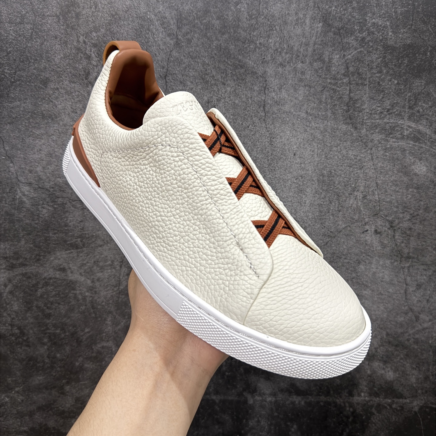 图片[3]-【顶级渠道版】杰尼亚TIZIANO低帮运动鞋 这款Tiziano低帮运动鞋摔花纹牛皮制成，饰以丰富的工艺细节，如骆马红棕色皮革嵌饰和手绘饰边。此优雅材质令这款动感十足的运动鞋转变为精致的休闲单品。耐用的橡胶鞋底可探索城市街道提供所有需的支持。 版型和产品细节：摔花纹牛皮面料，双色宽罗纹针织鞋带满足不同场合搭配不同风格，小牛皮内裡，鞋垫。内底、徽标压纹皮革中底，高弹力记忆鞋垫和超轻橡胶人字纹防滑鞋底，穿着舒服不凡。鞋底周圈加车大底边线。显得匠心十足。 尺码：3940414243444546-选品中心