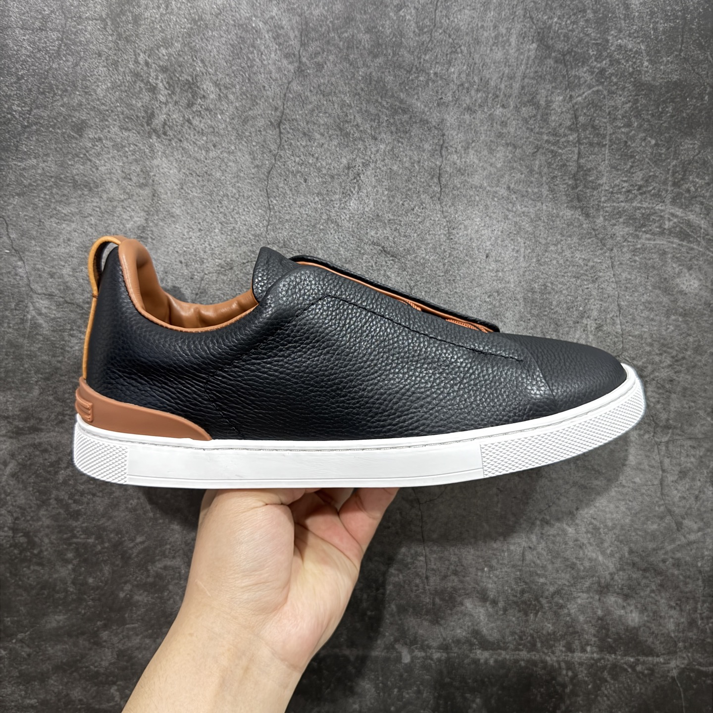 【顶级渠道版】杰尼亚TIZIANO低帮运动鞋 这款Tiziano低帮运动鞋摔花纹牛皮制成，饰以丰富的工艺细节，如骆马红棕色皮革嵌饰和手绘饰边。此优雅材质令这款动感十足的运动鞋转变为精致的休闲单品。耐用的橡胶鞋底可探索城市街道提供所有需的支持。 版型和产品细节：摔花纹牛皮面料，双色宽罗纹针织鞋带满足不同场合搭配不同风格，小牛皮内裡，鞋垫。内底、徽标压纹皮革中底，高弹力记忆鞋垫和超轻橡胶人字纹防滑鞋底，穿着舒服不凡。鞋底周圈加车大底边线。显得匠心十足。 尺码：3940414243444546-选品中心