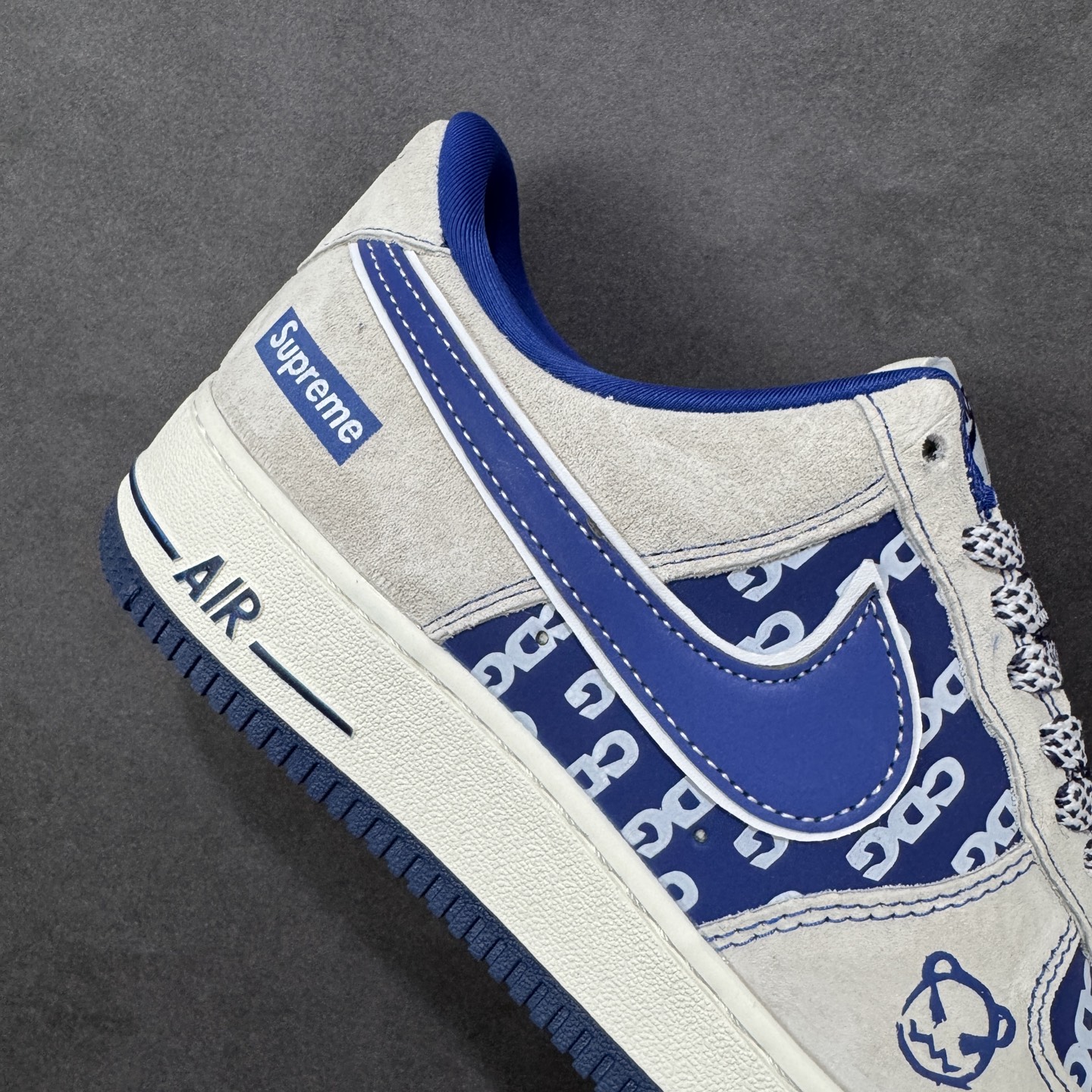 图片[6]-【定制版】蓝调潮范，经典联名｜Nike Air Force 1 Low x Supreme 当Nike Air Force 1 Low的经典鞋型碰撞Supreme的街头基因，这双直接把潮流氛围感拉满！浅灰麂皮的基底质感高级，宝蓝色的撞色设计亮眼却不张扬，鞋身满印的品牌元素与侧边的Supreme标识相互呼应，细节处的金属挂饰更是点睛之笔，让整双鞋的个性张力拉满。经典的Air气垫中底延续了空军一号一贯的舒适脚感，麂皮材质的选用则让鞋款的质感再升一级。不管是搭配街头风穿搭，还是作为收藏级单品，这双联名款AF1都能成为你鞋柜里的吸睛担当，用蓝白交织的潮范，踏出独属于你的街头步调。 货号：SY1388-022 尺码：36-45-选品中心