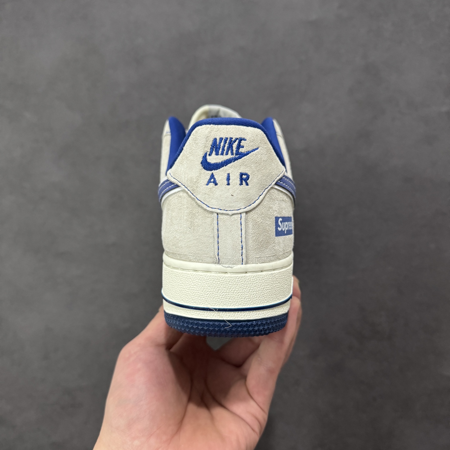 图片[4]-【定制版】蓝调潮范，经典联名｜Nike Air Force 1 Low x Supreme 当Nike Air Force 1 Low的经典鞋型碰撞Supreme的街头基因，这双直接把潮流氛围感拉满！浅灰麂皮的基底质感高级，宝蓝色的撞色设计亮眼却不张扬，鞋身满印的品牌元素与侧边的Supreme标识相互呼应，细节处的金属挂饰更是点睛之笔，让整双鞋的个性张力拉满。经典的Air气垫中底延续了空军一号一贯的舒适脚感，麂皮材质的选用则让鞋款的质感再升一级。不管是搭配街头风穿搭，还是作为收藏级单品，这双联名款AF1都能成为你鞋柜里的吸睛担当，用蓝白交织的潮范，踏出独属于你的街头步调。 货号：SY1388-022 尺码：36-45-选品中心