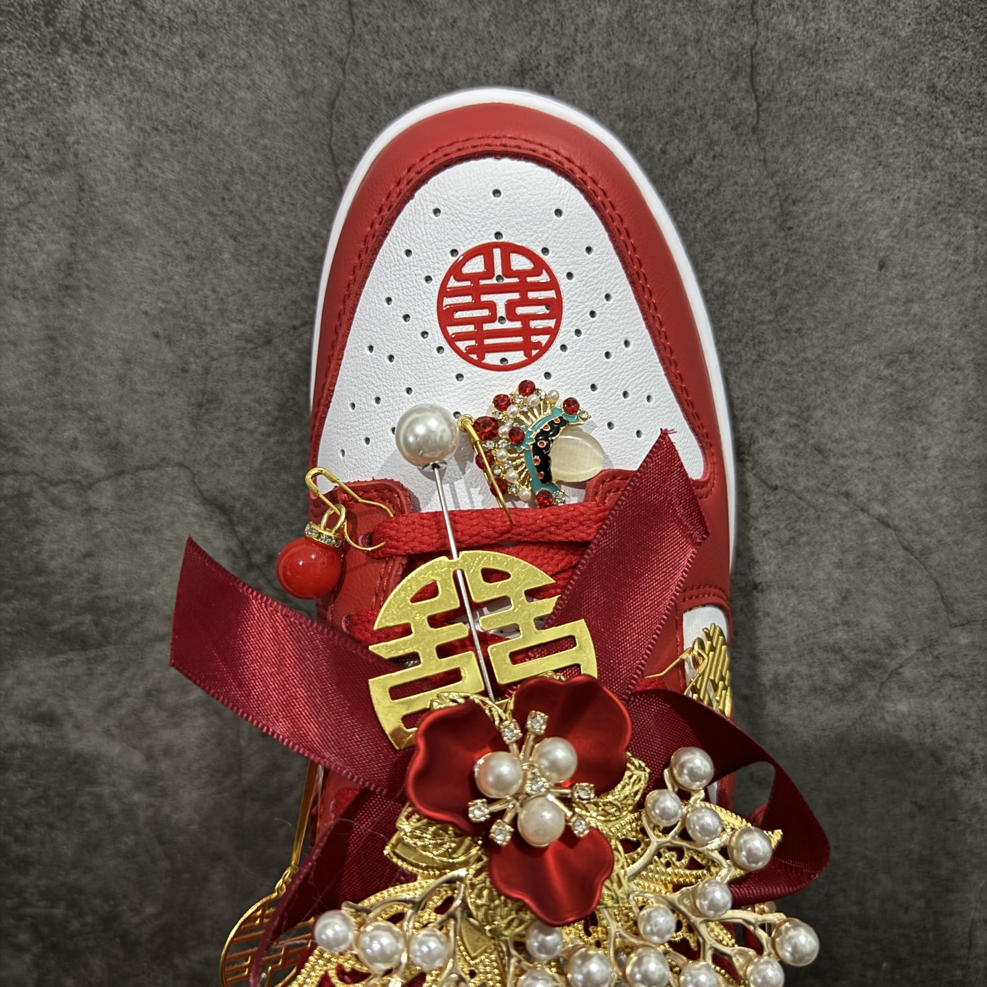 图片[5]-【纯原礼盒版本】NK Dunk Low 低帮婚鞋 锦绣良缘 货号：CU1727-100 该定制版球鞋选用原鞋款为Dunk SB系列球鞋，灵感来自中式婚庆，保留原鞋灰白红基调的基础上，叠加红色丝绒鞋带、增加整体的质感。配饰有双喜金属小挂件，再次呼应主题，呈现出中式婚礼的喜庆、庄重、雅致！鞋面金属挂件及鞋头喜字均可拆卸，同时满足婚庆和日常穿搭需求。本产品所有图片均为实物拍摄，受环境、设备影响会存在微小的色彩差异。定制球鞋均为纯手工定制，满足日常穿戴需求，穿着过程尽量避免剧烈运动和锐物划伤、避免使用高浓度的有机溶剂进行擦洗。 尺码：35.5 36 36.5 37.5 38 38.5 39 40 40.5 41 42 42.5 43 44 44.5 45 46-选品中心