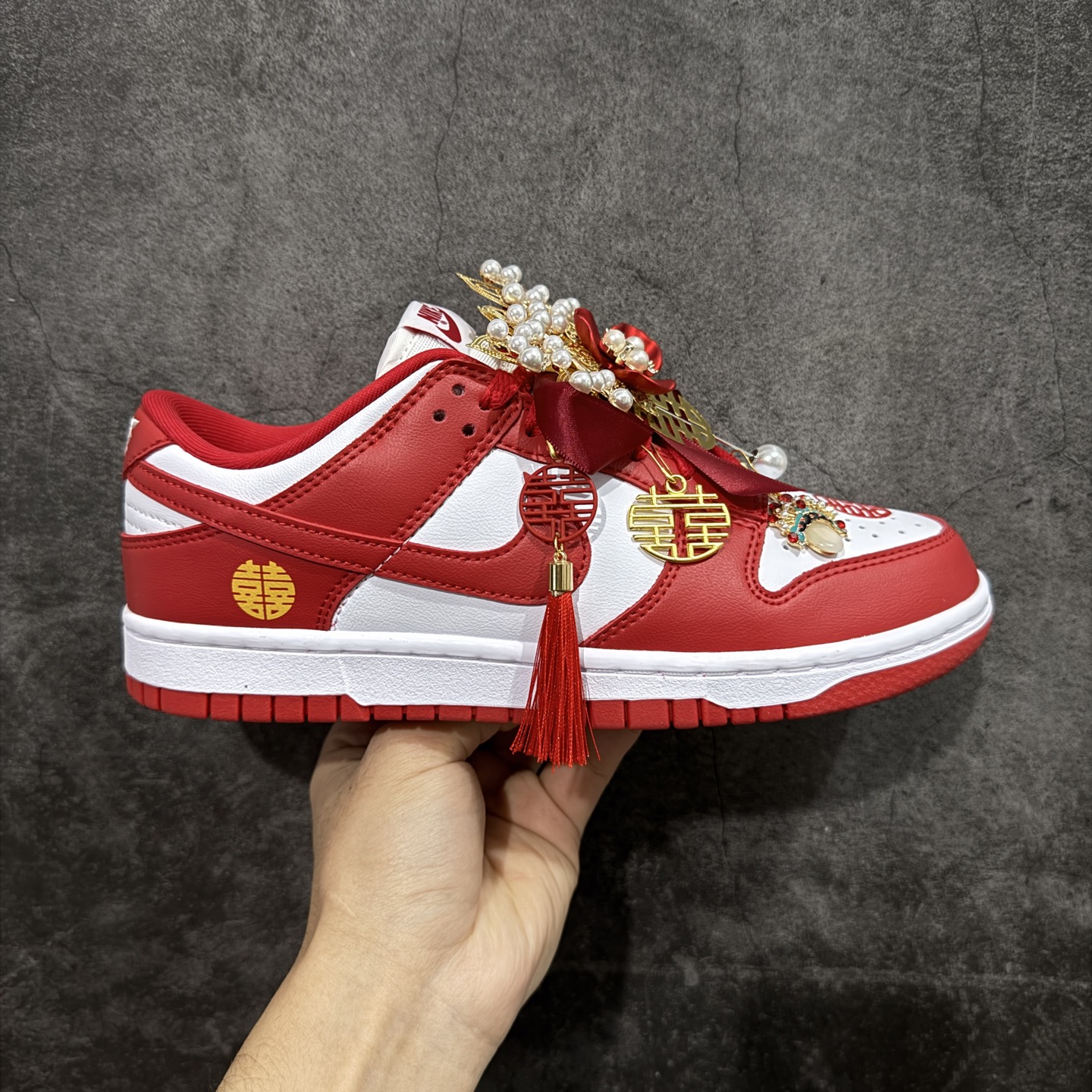 【纯原礼盒版本】NK Dunk Low 低帮婚鞋 锦绣良缘 货号：CU1727-100 该定制版球鞋选用原鞋款为Dunk SB系列球鞋，灵感来自中式婚庆，保留原鞋灰白红基调的基础上，叠加红色丝绒鞋带、增加整体的质感。配饰有双喜金属小挂件，再次呼应主题，呈现出中式婚礼的喜庆、庄重、雅致！鞋面金属挂件及鞋头喜字均可拆卸，同时满足婚庆和日常穿搭需求。本产品所有图片均为实物拍摄，受环境、设备影响会存在微小的色彩差异。定制球鞋均为纯手工定制，满足日常穿戴需求，穿着过程尽量避免剧烈运动和锐物划伤、避免使用高浓度的有机溶剂进行擦洗。 尺码：35.5 36 36.5 37.5 38 38.5 39 40 40.5 41 42 42.5 43 44 44.5 45 46-选品中心