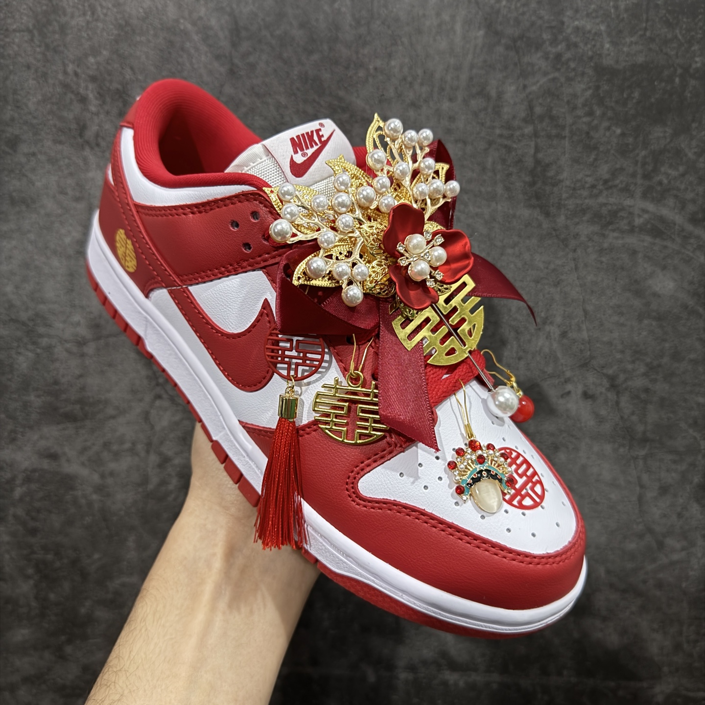 图片[3]-【纯原礼盒版本】NK Dunk Low 低帮婚鞋 锦绣良缘 货号：CU1727-100 该定制版球鞋选用原鞋款为Dunk SB系列球鞋，灵感来自中式婚庆，保留原鞋灰白红基调的基础上，叠加红色丝绒鞋带、增加整体的质感。配饰有双喜金属小挂件，再次呼应主题，呈现出中式婚礼的喜庆、庄重、雅致！鞋面金属挂件及鞋头喜字均可拆卸，同时满足婚庆和日常穿搭需求。本产品所有图片均为实物拍摄，受环境、设备影响会存在微小的色彩差异。定制球鞋均为纯手工定制，满足日常穿戴需求，穿着过程尽量避免剧烈运动和锐物划伤、避免使用高浓度的有机溶剂进行擦洗。 尺码：35.5 36 36.5 37.5 38 38.5 39 40 40.5 41 42 42.5 43 44 44.5 45 46-选品中心