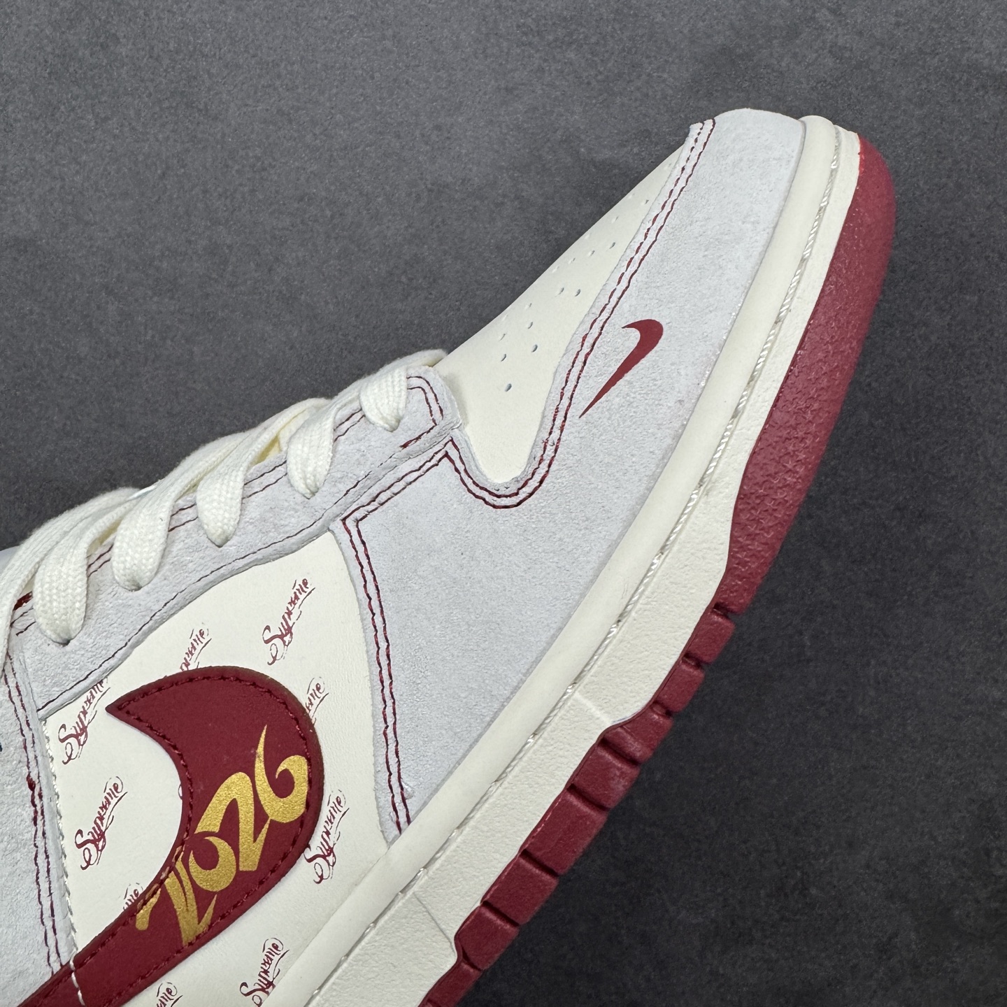 Nike SB Dunk Low × “Supreme马年限定”米白糅合酒红的复古调调，鞋身生肖马纹与联