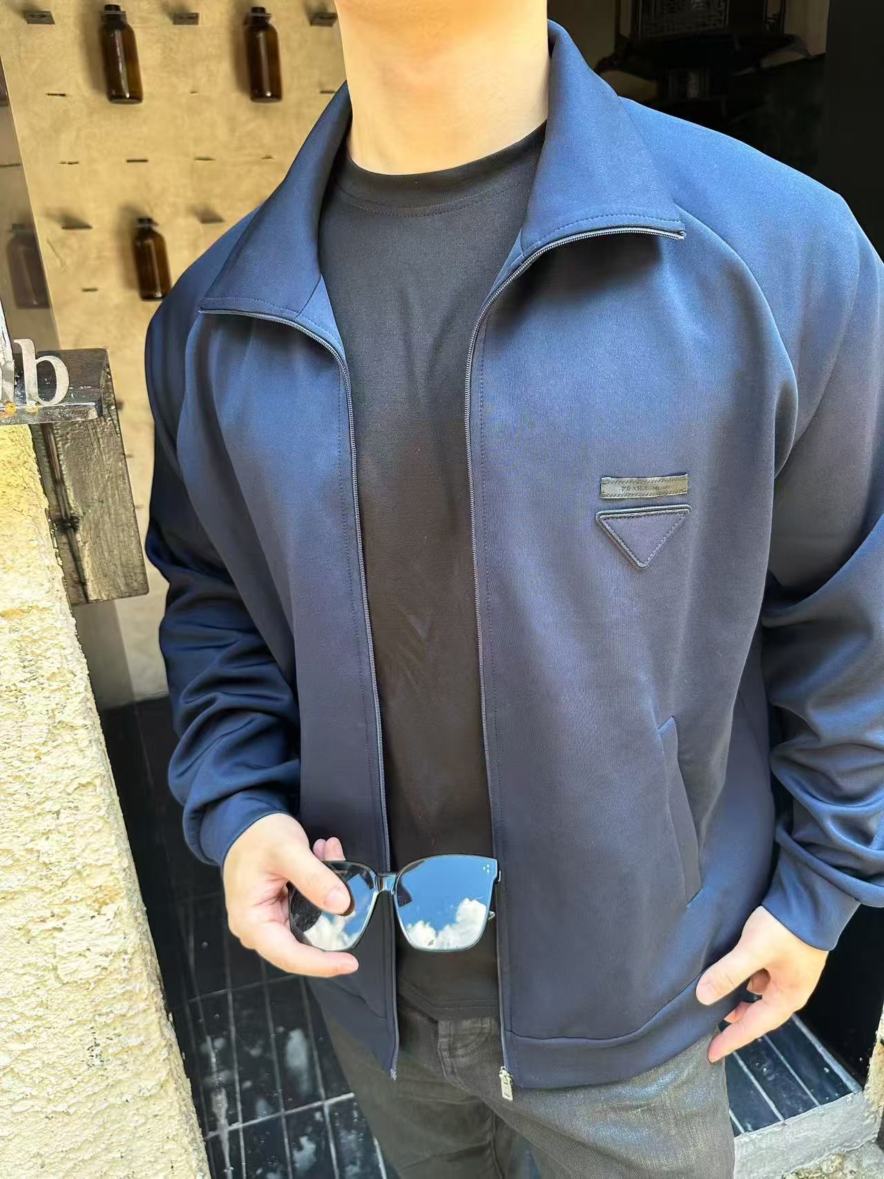 NO:457197,.PRADA triangular jacket fabric selection: A healthy cloth fabric woven with 80 natural cotton fibers as the main body, adding a small amount of bamboo fibers and polyester fibers. Cotton fibers provide natural breathability and comfort. The addition of a small amount of polyester fibers and bamboo fibers strengthens its durability and wrinkle resistance, with a smooth surface and a certain degree of elasticity. Functional treatment The addition of natural plant extracts effectively inhibits bacterial growth and reduces odor. The high-strength physical structure reduces dust mites adhesion without affecting its rapid sweating and evaporation, and maintains comfort. Pre-shrinkage process treatment The fabric is uniformly humidified by steam, squeezed with a heated roller and an elastic rubber blanket to force the fiber to retract, and finally fixes the form through cold air. After treatment, the shrinkage rate is controlled within 3. Auxiliary materials are one-to-one fabric triangular marks, one-to-one zipper heads, one-to-one water washing marks, etc.  SIZE:S M L XL exclusively available, prada, jackets & coats,alexander wang19860909.PRADA饰织物三角标夹克 面料选择: 以80天然棉纤维为主体,加入少量竹纤维与聚酯纤维等织造而成的健康布面料.棉纤维提供天然的透气性和舒适性,少量聚酯纤维和竹纤维的加入强化其耐用性和抗皱性,表面手感光滑且具有一定的伸缩性. 功能性处理 天然植物提取物的添加,有效抑制细菌滋生,减少异味.高支高密的物理结构减少尘螨附着且不影响其能快速排汗蒸发,保持舒适度. 预缩工艺处理 面料经蒸汽均匀加湿,用加热后的辊筒与弹性橡胶毯挤压,迫使纤维回缩,最后通过冷风降温固定形态.经过处理之后将缩水率控制在3以内. 辅料一比一织物三角标 一比一拉链头 一比一水洗标等 SIZE:S M L XL 独家专供,,prada,jackets & coats,alexander wang,Men's clothing