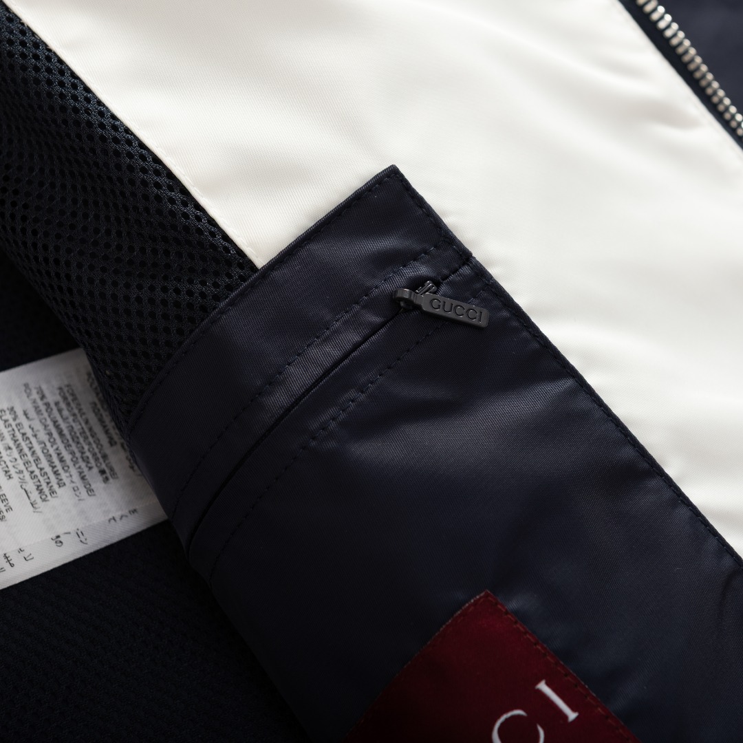 。GUCCI饰贴饰斜纹尼龙夹克面料选择：选用100%锦纶纤维紧密编织而成的蓝色密织斜纹尼龙面料。经纬纱线