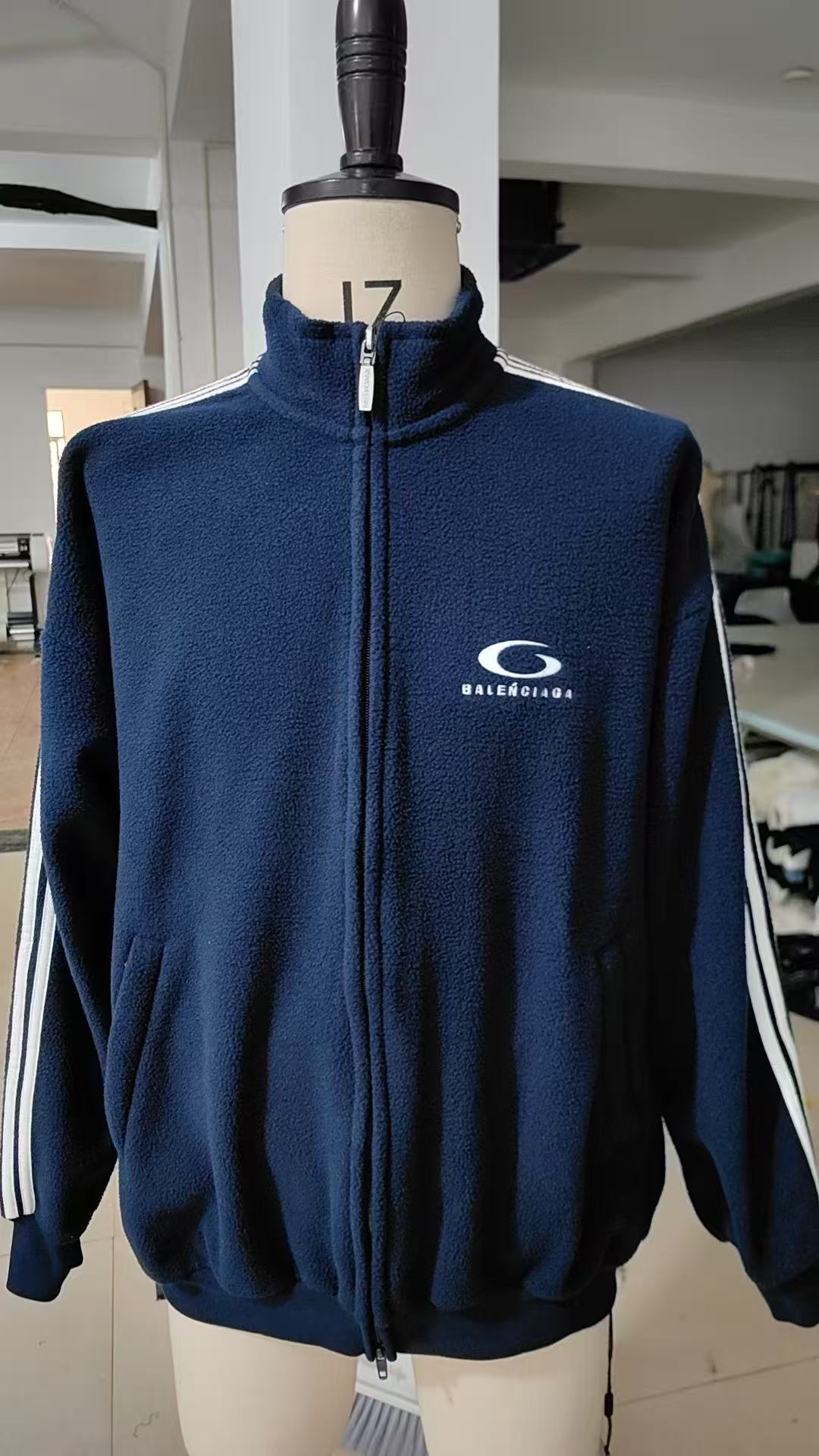 。BALENCIAGA摇粒绒饰刺绣外套面料选择：涤纶长丝通过针织圆机，将经纱和纬纱相互圈套编织成双面针织