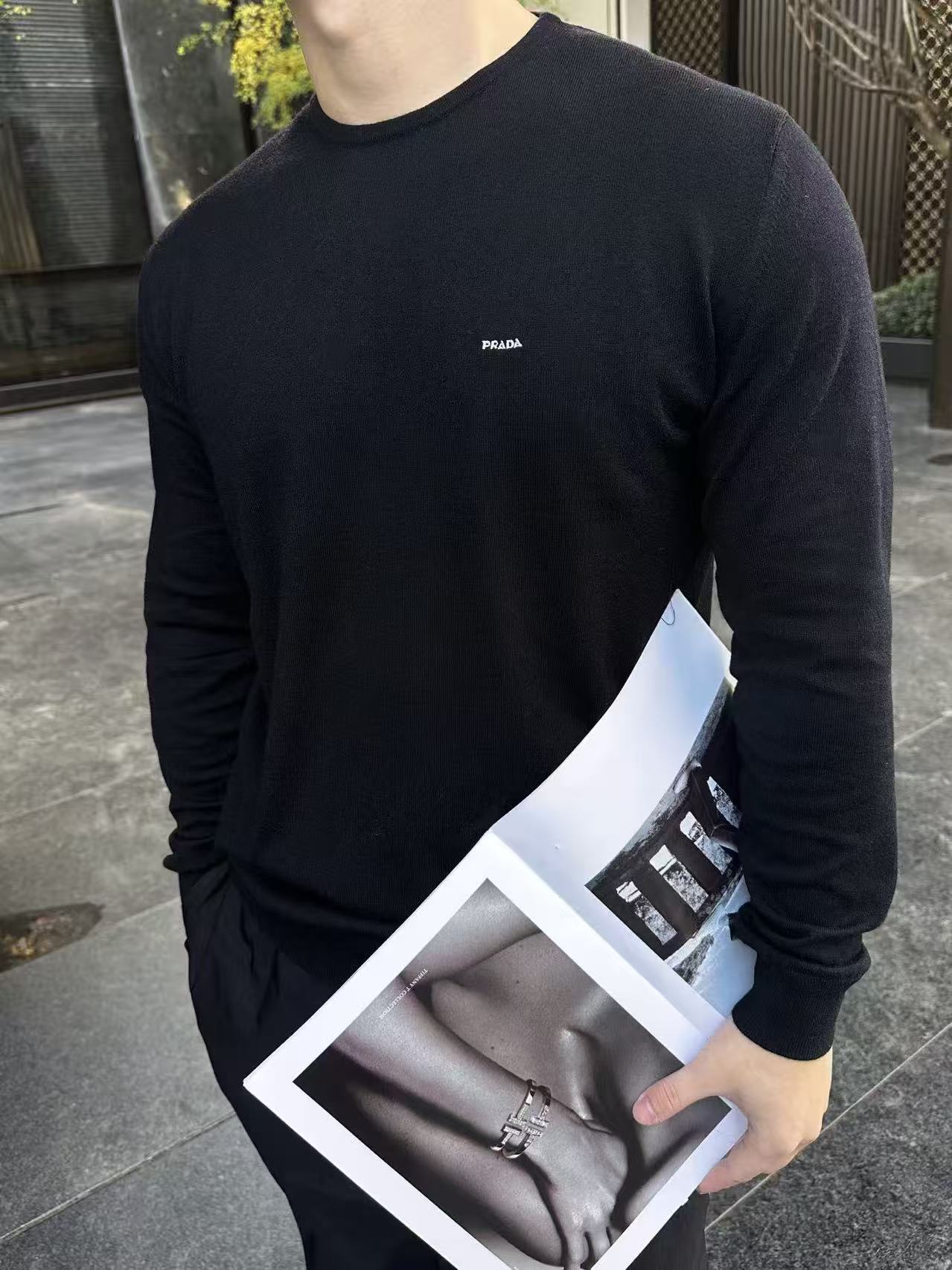 NO:690792,.PRADA 26SS Worsted Wool Long Sleeve is made of worsted wool material. This material has the following characteristics: Soft and light. Worsted wool fiber is fine, making the sweater soft to the touch, light and comfortable to wear. Good warmth The wool fiber has good thermal insulation properties and is suitable for wearing in colder weather. The fiber length is moderate and free of impurities to ensure the quality and comfort of the garment.  The knitting uses plain knitting technology to form the main part of the sweater. During the knitting process, the stitches must be kept even to avoid problems such as missing stitches and broken threads. After the ironing and knitting is completed, the sweater needs to be ironed to make it flat and crisp, improving the overall texture. The cuffs and hem are spliced using rib knitting technology to increase elasticity and fit, making the cuffs and hem more compact and stylish.  Raglan design The raglan part needs to be finely spliced with the main part to ensure smooth and natural shoulder lines. Logo embroidery has Prada's letter logo embroidered on the left chest of the sweater, which is an important part of the brand identity. The embroidery needs to be fine, flat, and perfectly integrated with the fabric. Size: S M L XL,, prada, sweaters,19860909.PRADA 26SS 精纺羊毛长袖 采用精纺羊毛材质,这种材质具有以下特点 柔软轻盈精纺羊毛纤维细腻,使得毛衣触感柔软,穿着轻盈舒适. 保暖性好羊毛纤维具有良好的保暖性能,适合在较冷的天气穿着. 纤维长度适中,无杂质,以保证成衣的质量和舒适度. 编织采用平纹针织工艺进行编织,形成毛衣的主体部分.编织过程中需保持针脚均匀,避免出现漏针、断线等问题. 整烫编织完成后,需对毛衣进行整烫处理,使其平整挺括,提升整体质感. 袖口与底边采用罗纹针织工艺进行拼接,增加弹性和贴合度,使袖口和底边更加紧致有型. 插肩设计插肩部分需与主体部分进行精细拼接,确保肩部线条流畅自然. 徽标刺绣在毛衣的左胸位置刺绣有Prada的字母徽标,这是品牌标识的重要部分.刺绣需精细、平整,与面料完美融合. Size: S M L XL,,prada,sweaters,,Men's clothing