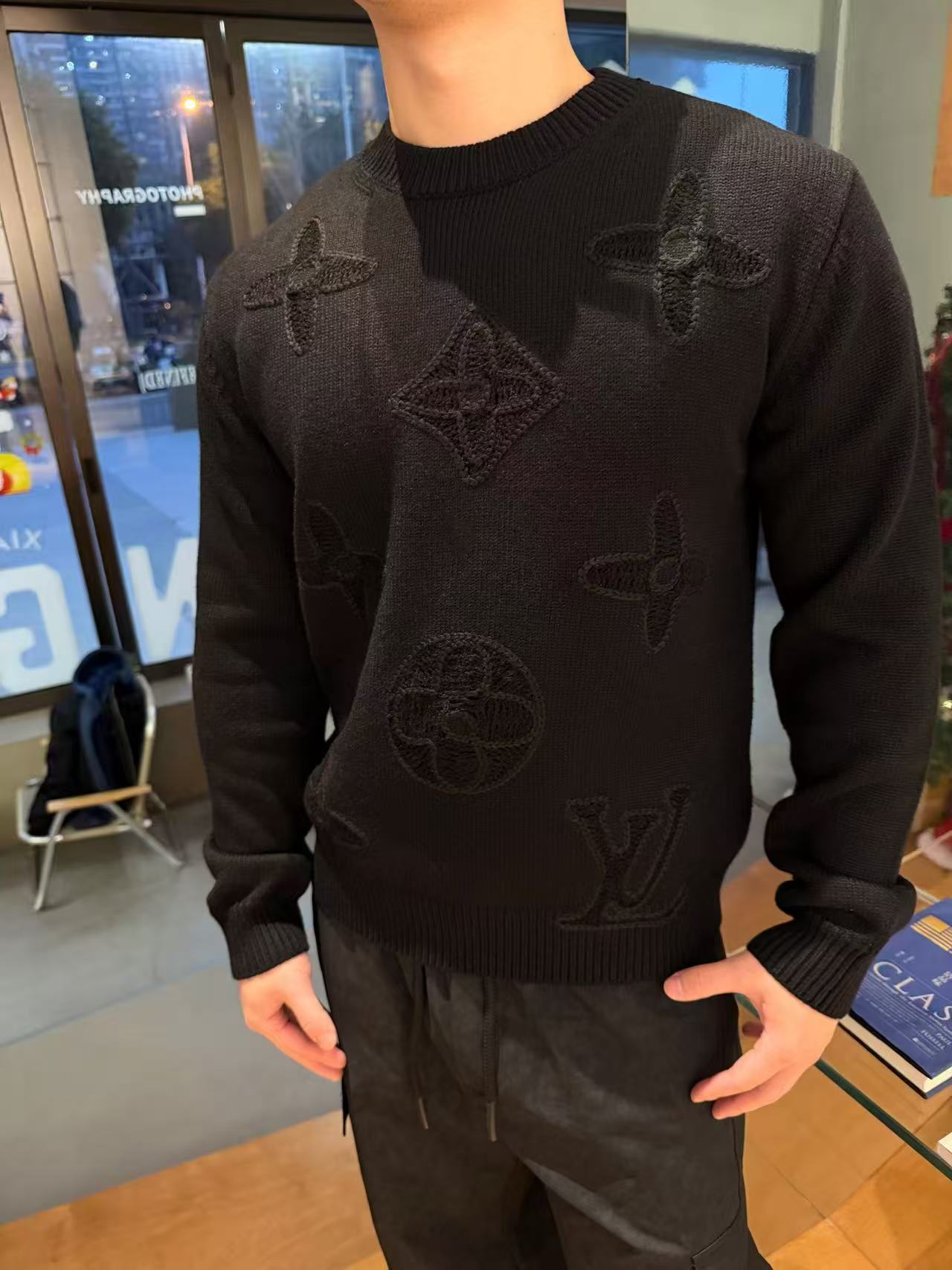 NO:690786,.26SS Donkey LV dark pattern jacquard sweater 1. Wool and cashmere blended fabrics. High-quality wool and cashmere raw materials are selected and blended according to a certain proportion. Wool provides warmth and durability, while cashmere gives clothing a soft and delicate touch. The combination of the two makes the fabric both comfortable and practical. Different from market products, our sweaters feel softer and waxier. 2. Yarn preparation, original analysis of yarn dyeing and custom dyeing  The yarn is stitched and dyed to ensure color reproduction and good color fastness. Yarn quality inspection conducts strict quality inspection on the yarn, including linear density, evenness, moisture regain and other indicators to ensure that the yarn quality meets production standards. 3. Embroidery process Using the Behringer embroidery machine, high precision can accurately control the position and density of stitches to ensure the accuracy and clarity of the embroidery pattern. Pattern Alignment When splicing different parts, it is necessary to ensure the continuity and alignment of the pattern to avoid dislocation or breakage.  Seamless splicing uses advanced seamless splicing technology to make the splicing smoother and more natural, improving wearing comfort. 4. Post-processing finishing and inspection Shrinking treatment uses the shrinking characteristics of cashmere fiber to shrunk sweaters. Ironing and Styling Ironing and styling The sweaters are ironed to make the clothes smoother and crisper while maintaining style characteristics. The temperature and pressure need to be precisely controlled during the ironing process to prevent the clothes from deforming or being damaged. Size: S—XL  The model is 170CM and 150 pounds, wearing size M is suitable,,louis vuitton,louis vuitton,sweaters,19860909.26SS 驴LV暗纹提花毛衣 1.羊毛羊绒混纺面料 精选高品质的羊毛与羊绒原料,按照一定的比例进行混纺.羊毛提供保暖性和耐用性,而羊绒则赋予衣物柔软细腻的触感,两者的结合使得面料既舒适又实用. 区别市场货、我们毛衣的手感更加软糯. 2. 纱线制备 纱线染色与订染解析原版 对纱线进行订染,确保颜色还原度、且色牢度良好. 纱线质量检测对纱线进行严格的质量检测,包括线密度、条干均匀度、回潮率等指标,确保纱线质量符合生产标准. 3.绣花工艺 使用百灵达绣花机 高精度能够精确控制针脚的位置和密度,确保刺绣图案的精准度和清晰度. 图案对齐在拼接不同部分时,需确保图案的连续性和对齐,避免出现错位或断裂. 无缝拼接采用先进的无缝拼接技术,使拼接处更加平整、自然,提升穿着的舒适度. 4.后期整理与检验 缩毛处理利用羊绒纤维的缩绒特性,对针织衫进行缩毛处理. 整烫与定型对针织衫进行整烫处理,使衣物更加平整挺括,同时保持款式特点.整烫过程中需要精确控制温度和压力,以防止衣物变形或损坏. Size: S—XL 模特170CM150斤 穿M码合适,,louis vuitton,louis vuitton,sweaters,,Men's clothing