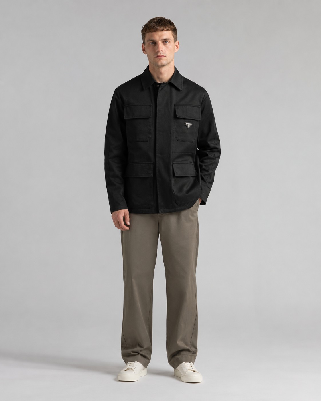 NO:935827,.PRA cotton workwear-style jacket fabric selection: 45° diagonal warp and weft interweaving to construct the fabric's bones. The closely arranged cotton yarns form a natural three-dimensional texture, giving a practical base that is anti-wrinkle and wear-resistant. At the same time, the matte texture echoes the rough aesthetics of the workwear style. It retains the natural skin-friendliness and sweat-absorbing ability of cotton fiber, while taking into account warmth and breathability. Craftsmanship and details  1 Utilizes the natural stiffness of the fabric and reinforces the shoulder seams with double layers of cotton yarn to create a sculptural wide shoulder profile to avoid collapse and deformation. Invisible threaded strips are embedded in the cuffs to ensure freedom of movement. 2 Through low-temperature pressing and the natural hardness of the twill fabric, a 30-degree stiffness angle is created to make the neckline fit the neck curve and improve wearing comfort.  3 Abandon the traditional lining and use the stiffness of the fabric itself to shape the silhouette, reducing redundant layers while improving breathability. 4 Hidden button closure and flat bottom edge design strengthen the balance between tough temperament and loose fit, avoiding a bloated feeling. 5: Symmetrical flap patch pockets enhance practicality, and the three-dimensional silhouette adds a sense of layering. Tight stitching at the edges makes the bag firm while adding beauty. Accessories are customized one-to-one with triangle labels and one-to-one customized metal buckles.  One-to-one custom wash label SIZE: S M L XL,, prada, jackets & coats,19860909.PRA棉质工装风夹克 面料选择 以45°斜向经纬交织构筑面料筋骨,紧密排列的棉纱形成天然立体肌理,赋予抗皱耐磨的实用基底,同时通过哑光质感呼应工装风的粗粝美学,其保留了棉纤维天然的亲肤性和吸汗能力,同时又兼顾保暖性和透气性. 工艺与细节 1利用面料天然硬挺性,通过双层棉纱加固肩线接缝,打造雕塑感宽肩轮廓,避免软塌变形.袖口内嵌隐形螺纹衬条,确保举手投足间的自如. 2通过低温压烫与斜纹布自然的硬度融合,打造30度力挺角度,使领口贴合颈部曲线,提升穿着舒适度. 3摒弃传统衬里,以面料本身的挺括度塑造廓形,减少冗余层次的同时提升透气性. 4隐藏式纽扣开合和平直底边设计强化硬朗气质与宽松版型形成平衡,避免臃肿感. 5:对称翻盖贴袋强化实用性,立体廓形增添层次感.边缘处紧密的缝线使袋体牢固的同时又增添美感. 辅料一比一定制三角标 一比一定制金属扣 一比一定制洗水唛领标 SIZE: S M L XL,,prada,jackets & coats,,Men's clothing