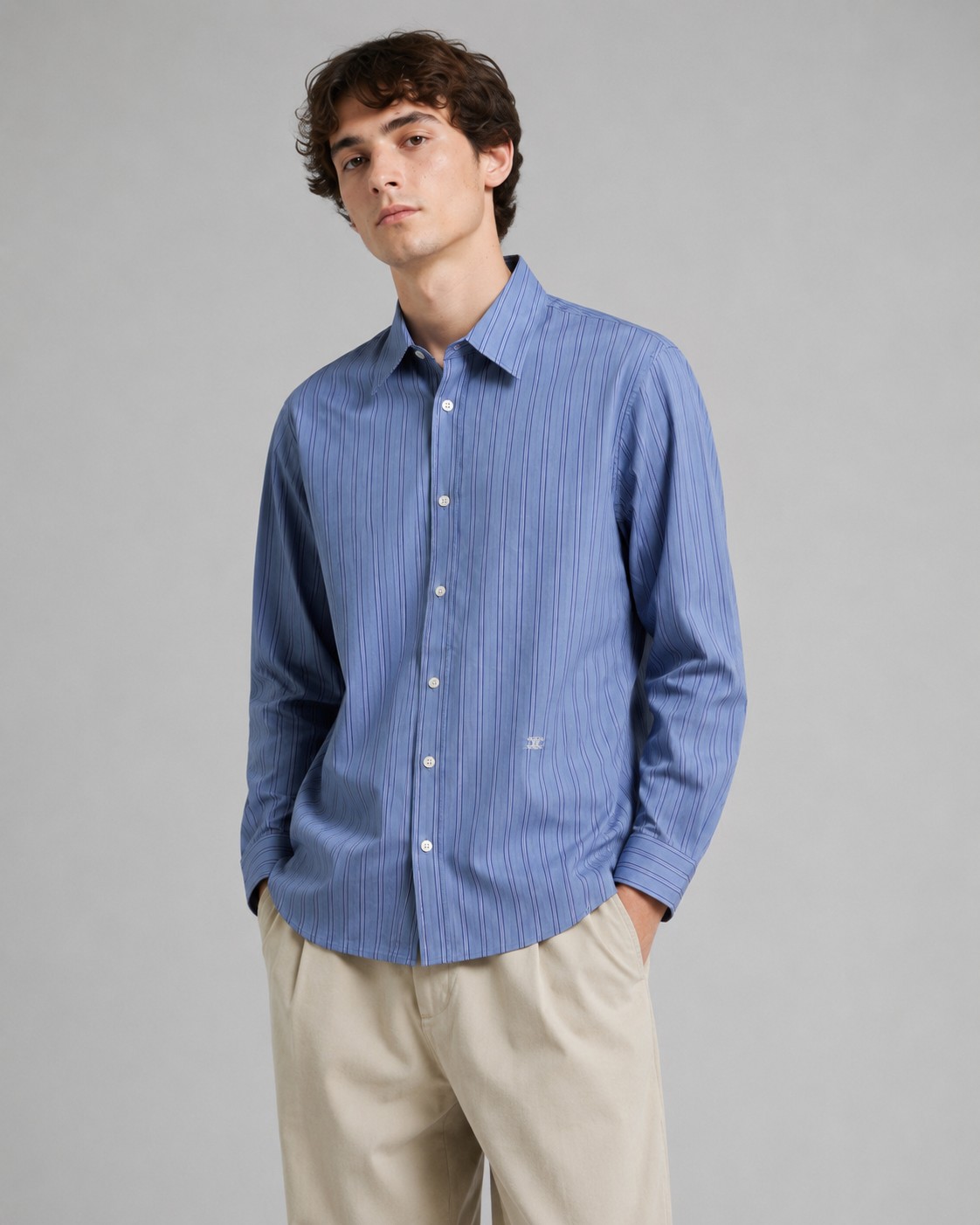 NO:948941,.Cel embroidered classic striped shirt. Fabric selection: Made of 100% cotton poplin fabric. The pure cotton fiber can quickly absorb moisture and perspire, making it refreshing and not stuffy when worn for a long time. The unique plain weave process of poplin makes the fabric both soft and skeletal. It is not easy to wrinkle and deform, and the upper body is neat and clean. In addition, the whole body is made of fine blue and white stripes, and the light color scheme is gentle and elegant, which can meet the needs of different scenes. Embroidery process  The waist pattern is embroidered using a Tajima high-speed embroidery machine, equipped with a 12-pin independent control system and a 0.01mm stepper motor, achieving high-speed operation of 1 stitch per second. The machine is equipped with an intelligent thread breakage detection function that can automatically stop within 0.3 seconds of thread breakage to avoid stitch misalignment; the tension closed-loop control system adjusts the upper thread and bottom thread in real time  The thread tension ensures that the white embroidery thread on the cotton is three-dimensional and full without being tight and wrinkled. The curve of the pattern adopts the minimum stitch distance, and the stitch angle changes in real time with the curvature of the curve to form a continuous and smooth line, creating a three-dimensional convex feeling. After the embroidery is completed, high-temperature ironing and thread trimming are performed to ensure that the pattern is smooth and compliant, and it is not easy to lose thread or warp after long-term wear.  Details: 1. The collar adopts double-layer reinforcement technology, which is not easy to collapse and deform after long-term wear. The collar angle is softly curved, which can modify the neck line without being too sharp, and is neat and decent. 2. The inner side of the placket has hidden hemming treatment to avoid fabric burrs and enhance structural stability. It is not easy to deform after repeated washing. Accessories are customized one to one. Buttons are customized one to one. Three standards. Size: 36 38 40 42,, shirts,19860909.Cel饰刺绣经典条纹衬衫 面料选择: 选用百分百棉府绸面料,纯棉纤维能快速吸湿排汗,长时间穿着也清爽不闷,府绸独特的平纹织造工艺,让面料兼具柔软度与骨感,不易起皱变形,上身利落干净. 加之通体细密蓝白相间条纹,浅淡配色温柔又显气质,能满足不同场景需求. 绣花工艺 腰间处图案绣花采用田岛高速绣花机,搭载12针位独立控制系统与0.01mm级步进电机,实现每秒钟1针的高速运转.机器配备的智能断线检测功能,能在断线0.3秒内自动停机,避免针脚错位；张力闭环控制系统则实时调节面线与底线张力,确保白色绣线在棉布上既立体饱满又不紧绷起皱.图案的曲线采用最小针距,针迹角度随曲线弧度实时变化,形成连续流畅的线条,打造立体凸起感.刺绣完成后进行高温熨烫与线头修剪,确保图案平整服帖,久穿也不易脱线、起翘. 细节: 1.领座采用双层加固工艺,久穿不易塌软变形,领角弧度柔和,既能修饰颈部线条,又不会过于尖锐,利落得体. 2.门襟内侧暗藏包边处理,避免面料毛边,同时增强结构稳定性,多次洗涤也不易变形. 辅料一比一定制纽扣 一比一定制三标 Size:36 38 40 42,,shirts,,Men's clothing