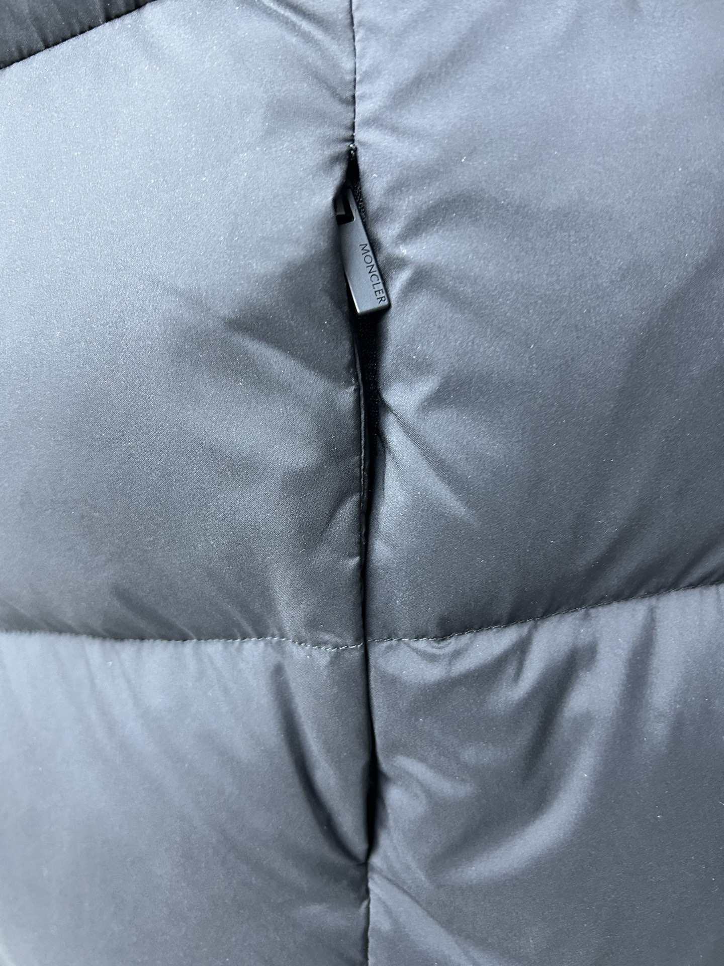 Moncler Fusain short down jacket inspired by racing. Features quilted nylon, lightweight warmth, sleek silhouette, hood, and reflective zipper. Available in black and off-white.-Big cat