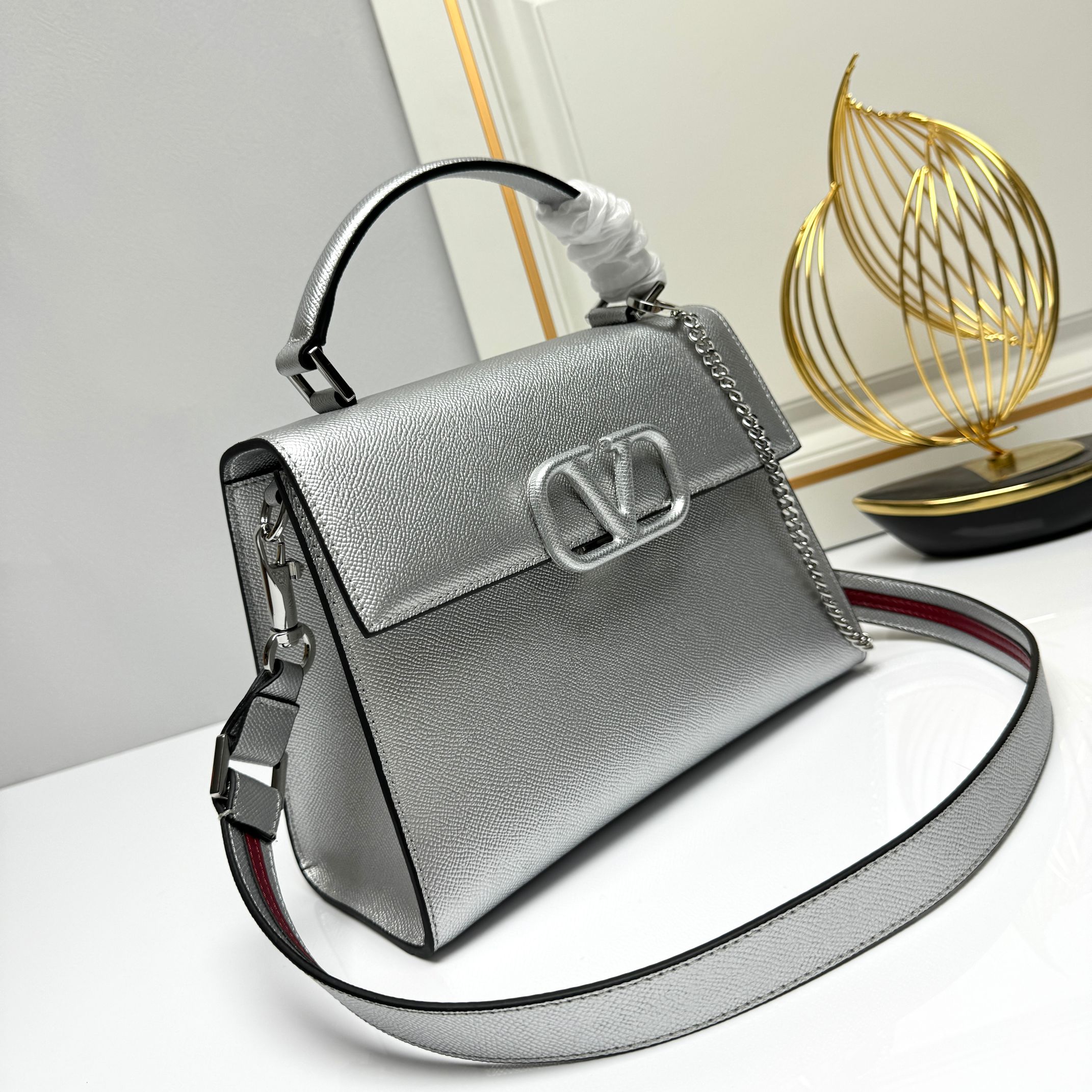 Valentino  VSling 手袋，以簡約大方的立体外观搭配哑光V Logo，可手拎，背带长度可调