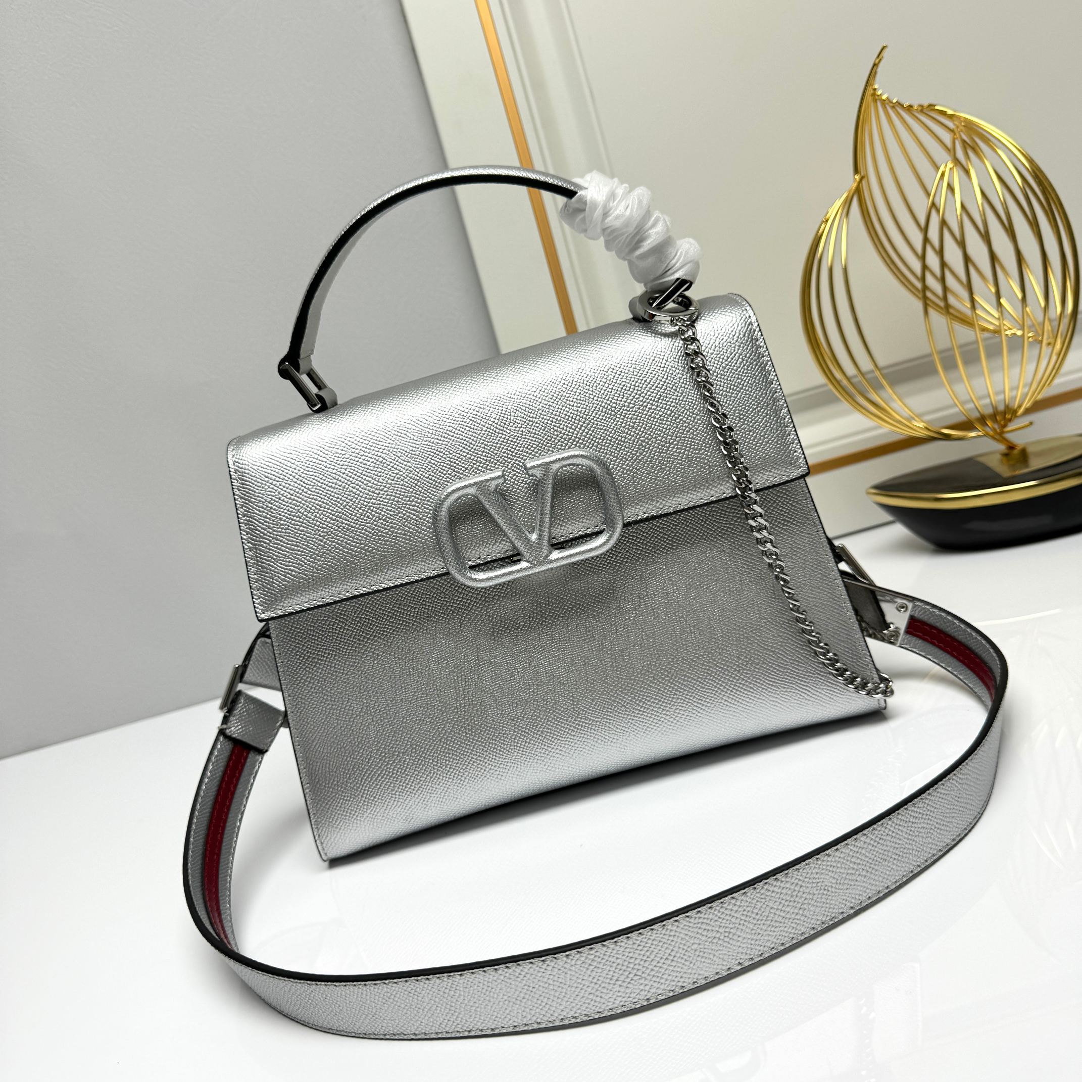 Valentino  VSling 手袋，以簡約大方的立体外观搭配哑光V Logo，可手拎，背带长度可调