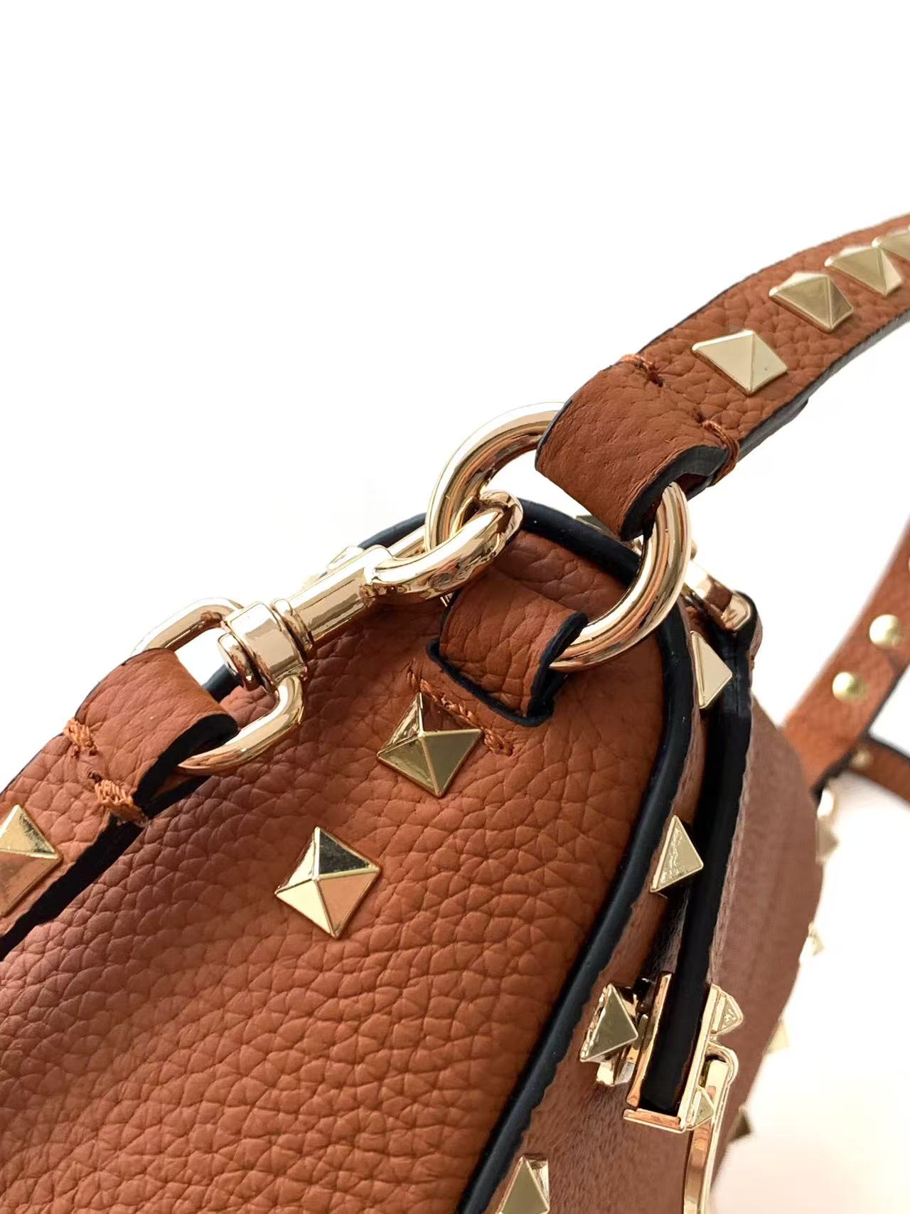 🆕 Garavani Rockstud 小号粒面小牛皮斜挎包,标志性的钩扣开合设计经重新诠释，止挡拉链拉