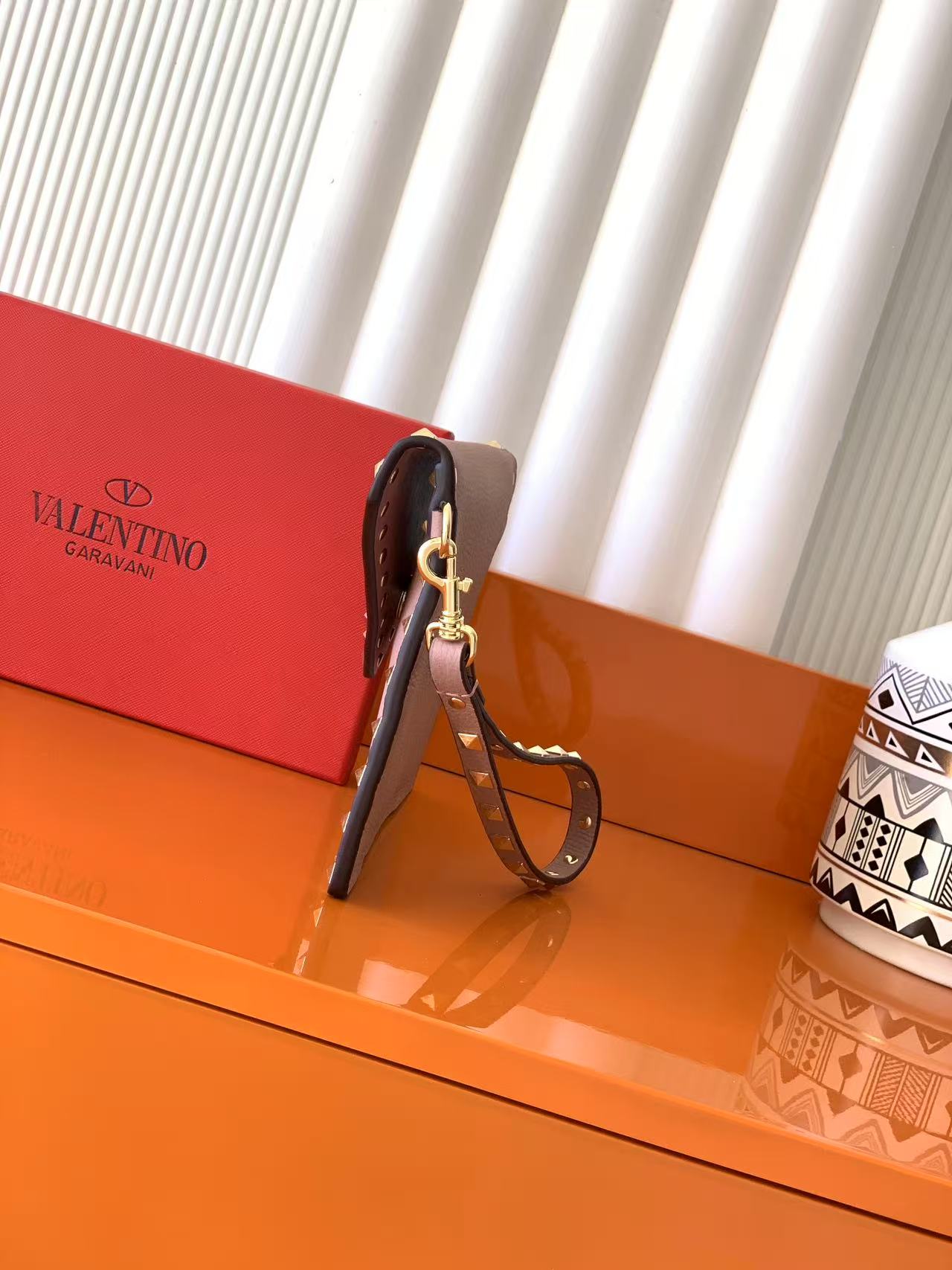 - VaIentino铆钉收纳包 - 铆钉手拿包采用信封式设计 - 具有磁扣开合.翻盖开口. - 一个带多卡夹的主隔层、