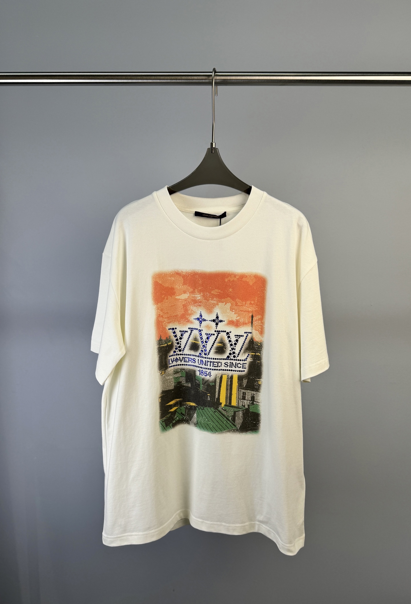 NO:315557,Louis Vuitton, a new early spring style landscape printed short-sleeved T-shirt, with Paris roof scenery as the background, outlined with illuminated crystals. The LV Vers United logo on the 2025 spring and summer show. The LV Vers logo on the back shows a washing and fading effect, injecting a chic atmosphere, loose style, and the same style of men and women. Size S M L,,louis vuitton,louis vuitton,louis vuitton, versace,T-shirt,tees,t-shirt,alexander wang19860909Louis Vuitton 路易 早春新款 风景印花图案短袖T恤、将巴黎屋顶风光作为背景,以莹泽仿水晶勾勒 2025 春夏秀场的 LV Vers United 标识.背后的 LV Vers 标识呈现水洗和褪色效果,为休闲造型注入别致气息、宽松版型、男女同款 码数S M L,,louis vuitton,louis vuitton,louis vuitton,versace,T-shirt,tees，t-shirt,alexander wang,Women's clothing