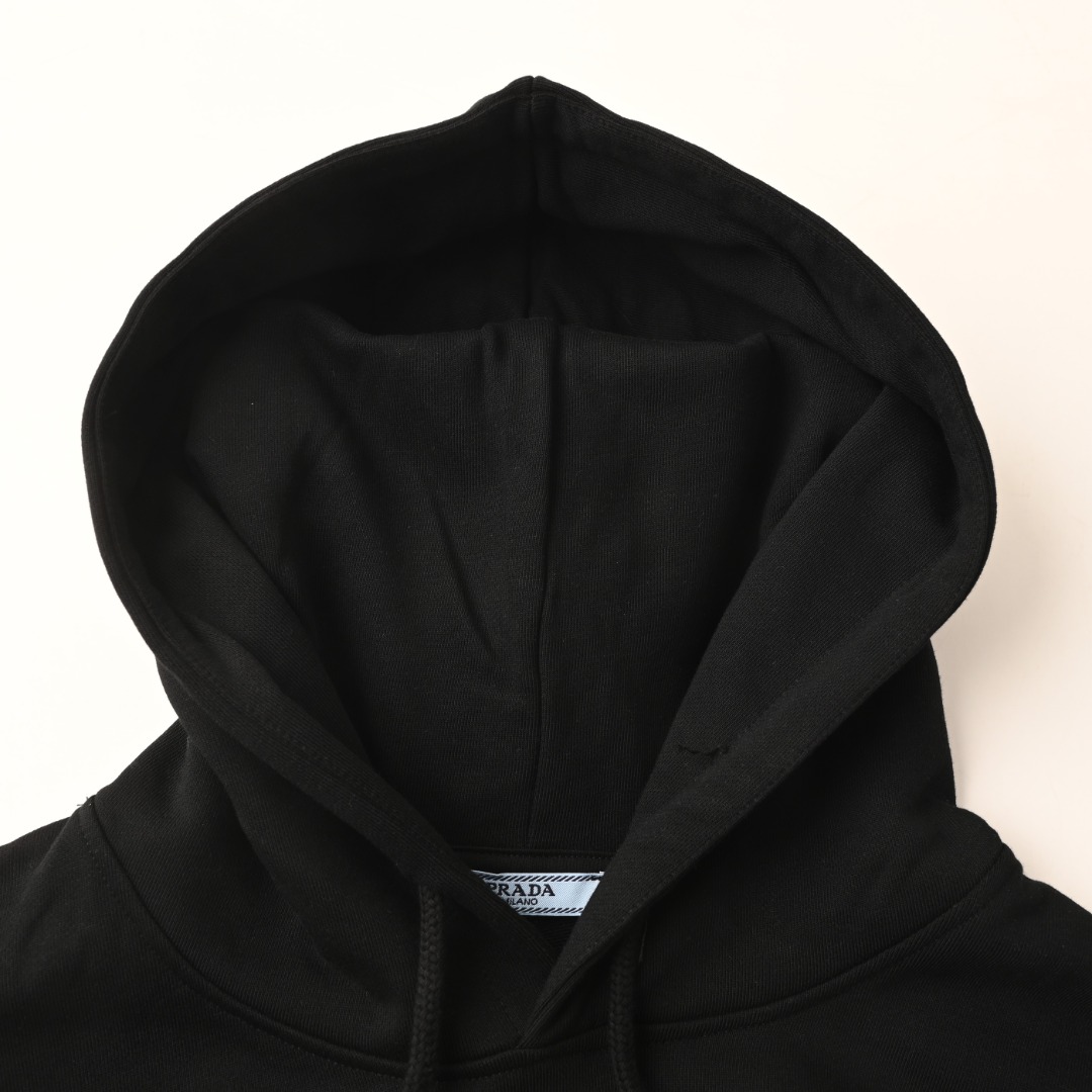 正品级💰370 Prada/普拉达PRD 假口袋三角铁标徽章连帽卫衣 经典款款我们最在意的就是面料和版型，P家经典修身版型，特殊立裁工艺， 上身线条流畅，不管偏胖或是胖瘦的身材，都能最大程度的得到修饰。 420克重纯棉面料毛圈底定制32支2*2螺纹 成衣两遍水洗处理， 面料舒适亲肤无异感 定制定染面料 纺织密度高 垂感佳 不易变形， 厚织感加上紧密纺纱工艺 不会影响卫衣的透气性 成色的饱和度很高 ， 胸前侧边假口袋三角铁标徽章，搭配大袋鼠口袋，厚度给足，又能做到柔软舒适， 上身就知道是顶级牛货。男女同款，正常版型，低调气质单品。 颜色：黑色、白色 Size：XS-L