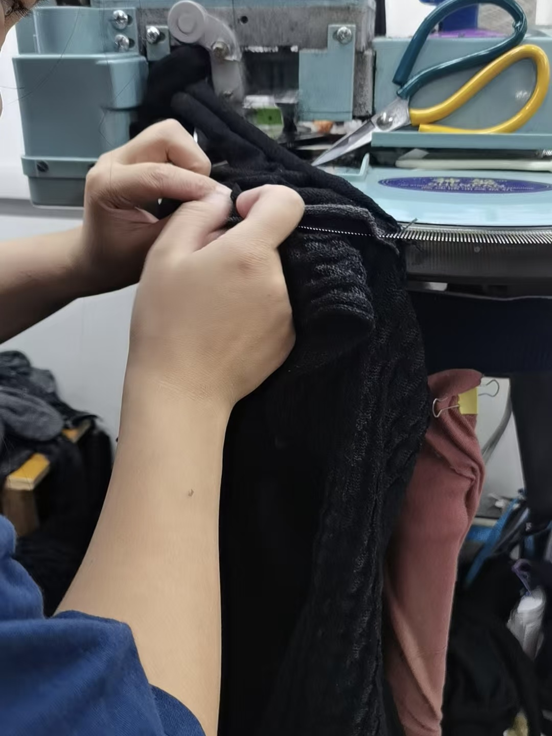 Proceso de producción de la chaqueta de punto VERSACE con cremallera y cuello alto, jacquard con imagen trasera