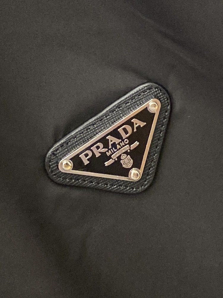 ￼ 普拉达、2025新品夹克外套，时尚帅气，简约百搭款，胸前五金装饰三角标logo，定制原版面料，不仅挺
