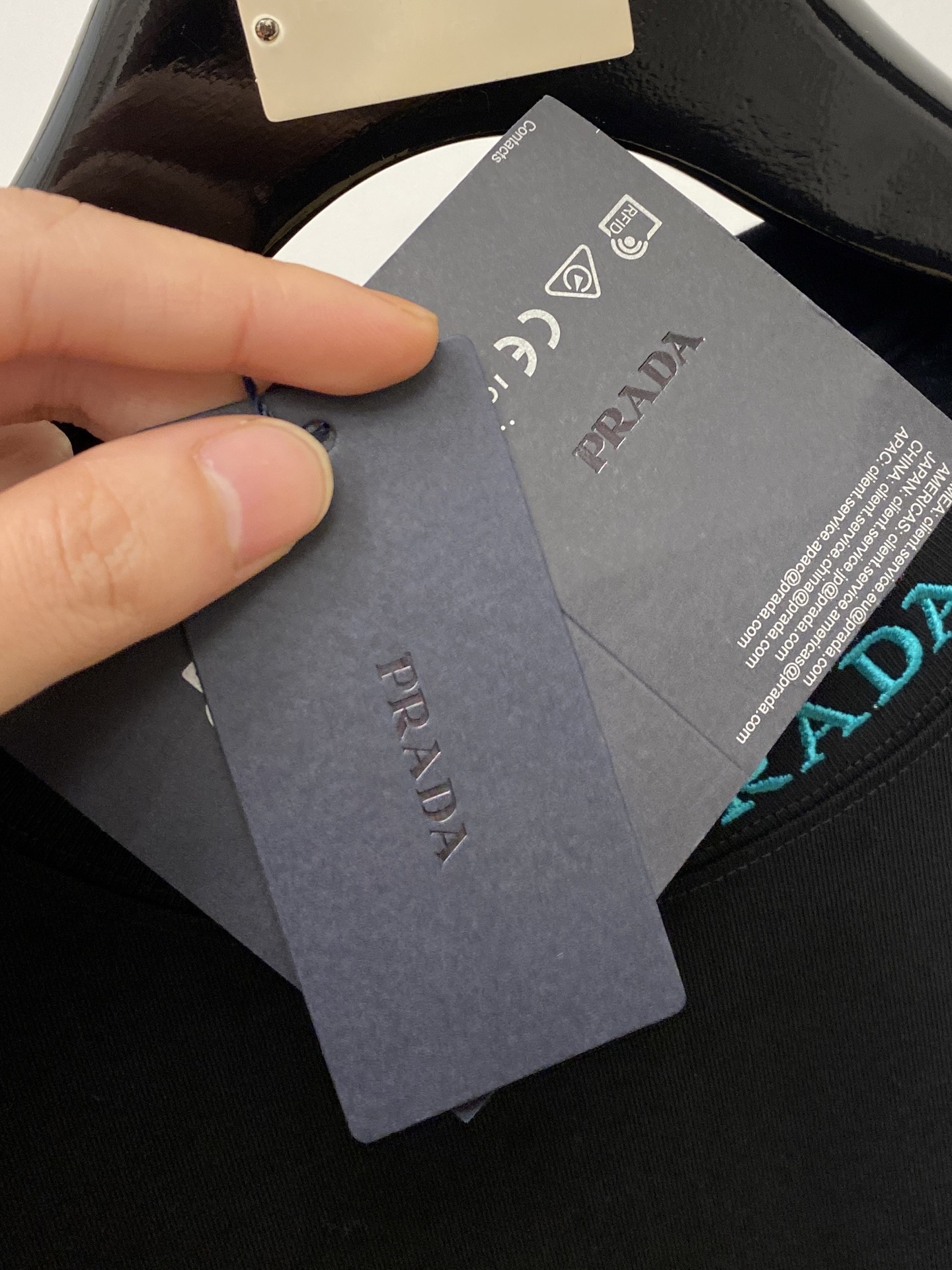 普拉达、2025新品短袖T恤，帅气时尚，简约百搭款。胸前五金装饰三角标logo，面料棉 不仅挺括，保持潮