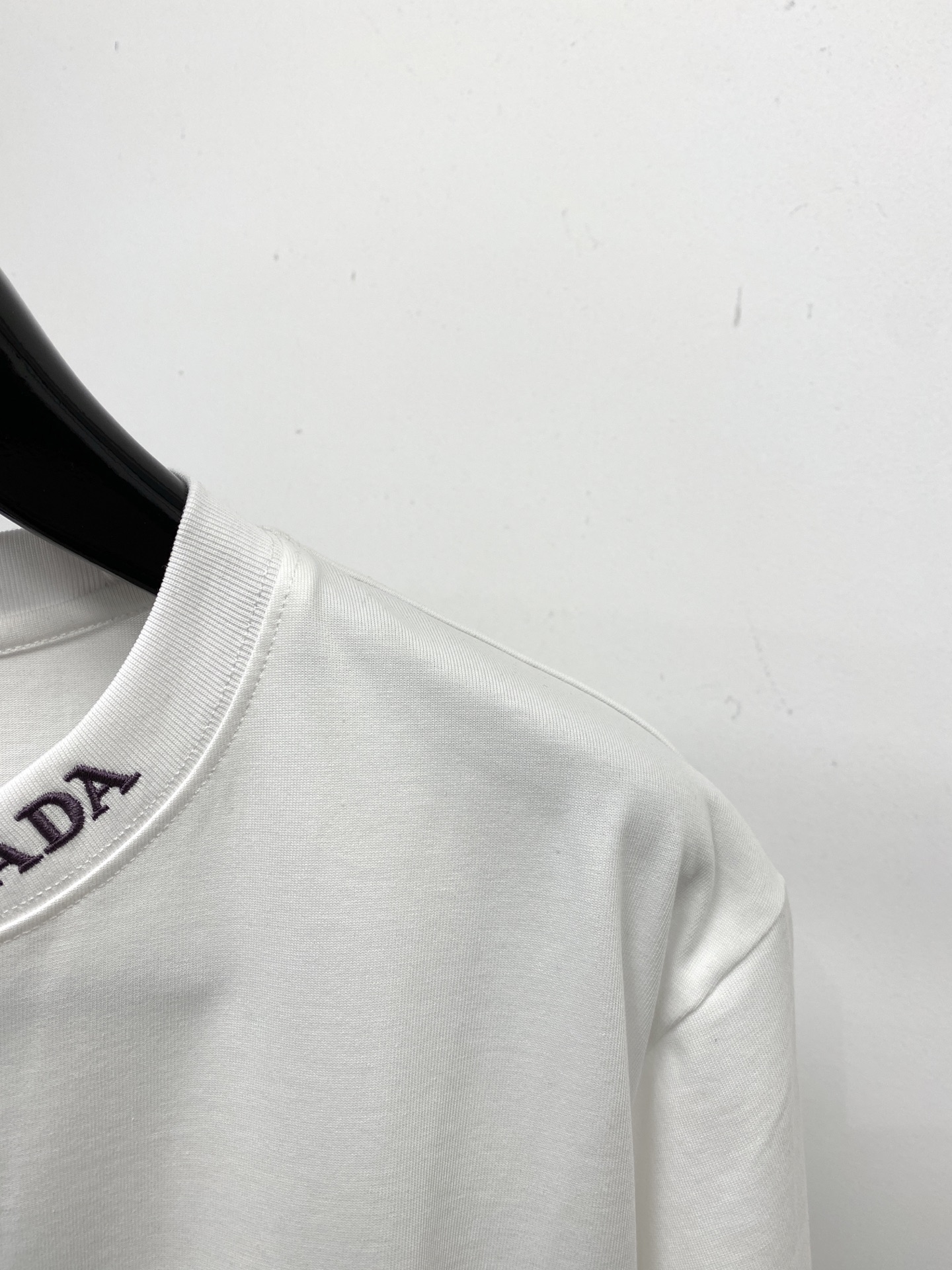 普拉达、2025新品短袖T恤，帅气时尚，简约百搭款。胸前五金装饰三角标logo，面料棉 不仅挺括，保持潮