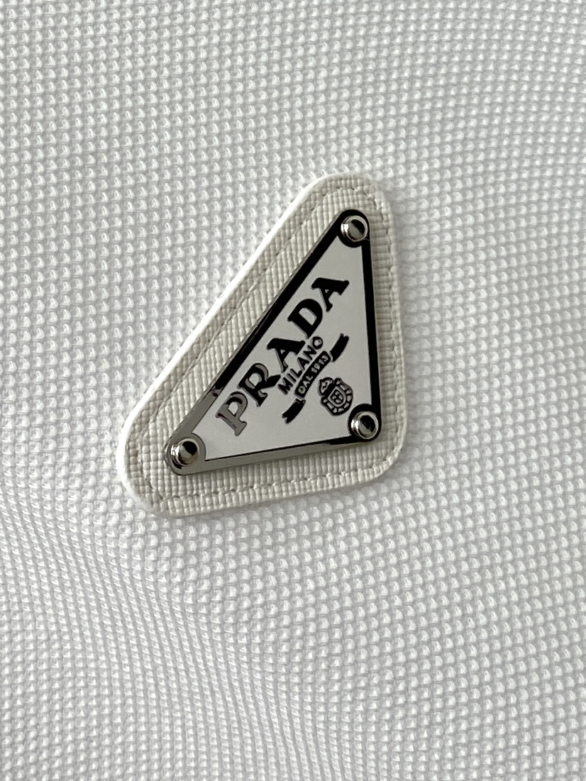 普拉达、2026新品短袖T恤，帅气时尚，简约百搭款。胸前五金装饰三角标logo，面料棉 不仅挺括，保持潮