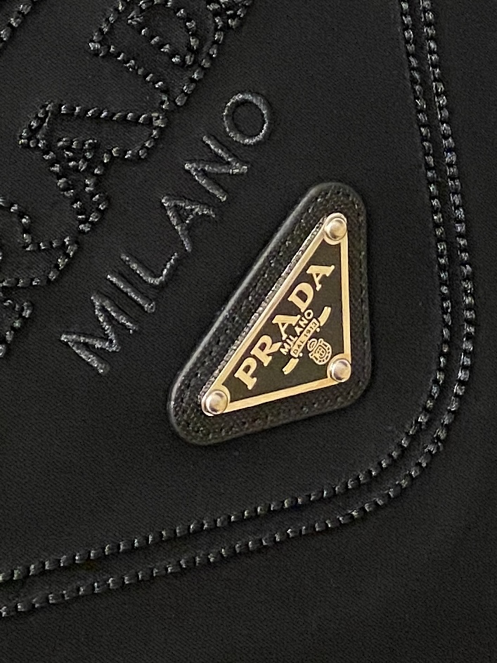 普拉达、2026新品短袖T恤，帅气时尚，简约百搭款。胸前精致刺绣五金装饰图案logo，面料棉 不仅挺括，