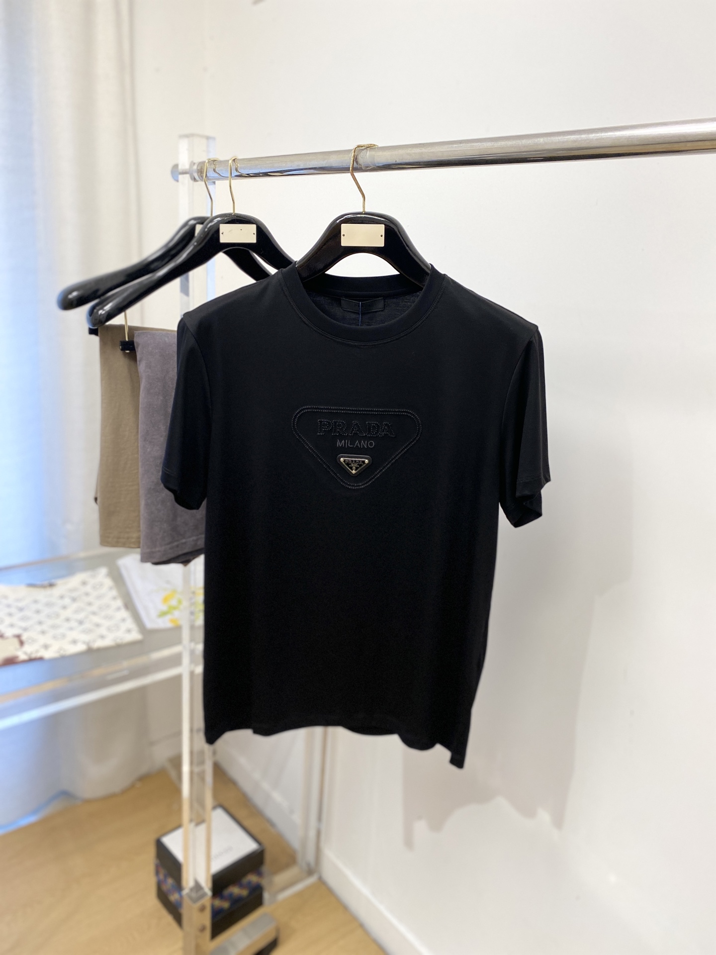 普拉达、2026新品短袖T恤，帅气时尚，简约百搭款。胸前精致刺绣五金装饰图案logo，面料棉 不仅挺括，