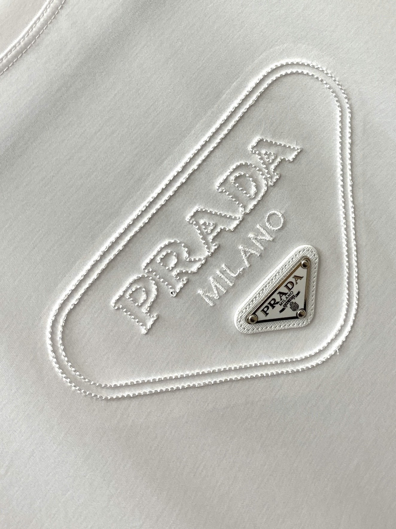 普拉达、2026新品短袖T恤，帅气时尚，简约百搭款。胸前精致刺绣五金装饰图案logo，面料棉 不仅挺括，