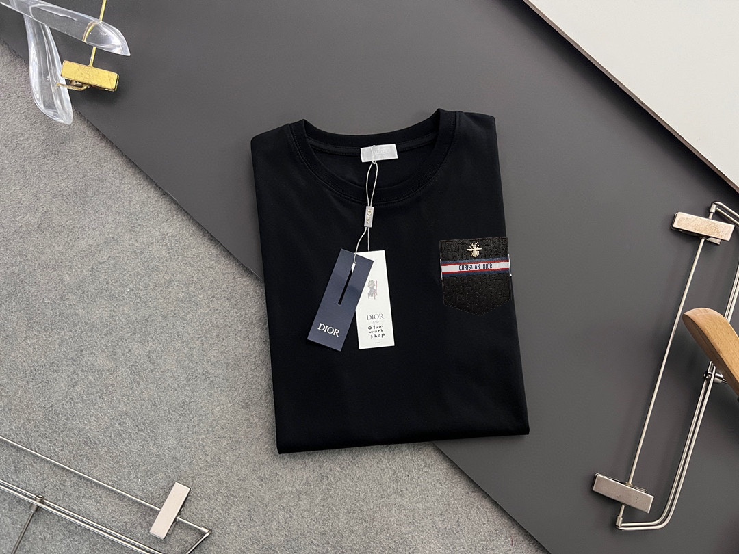 P70，  DIor迪奥
2025早春新款短袖  胸口手工定制logo
纯手工订做金丝线  下摆经典钮扣手缝
官网同步  专柜（百分之百纯棉面料 ） 贴肤舒适
耐看又好穿  原厂工艺一丝不苟
定制280克同缸染面料   手感非常舒服
最新砖柜同步  OS落肩版型  时尚又个性
超级百搭好看的一款  男女都非常合适
人手必备款  吊牌  领标  水洗麦  三标齐全 码数：S-XXL码