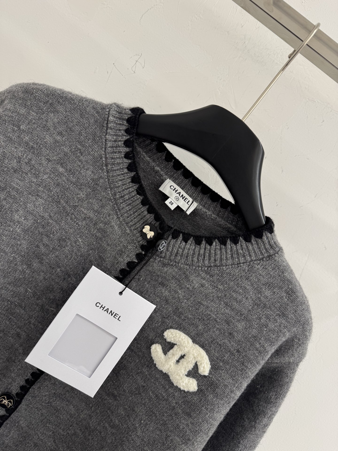 Chanel 圆领纽扣开衫‌设计，整体设计融合了品牌 元素与现代简约风格，纯色风格 简约百搭