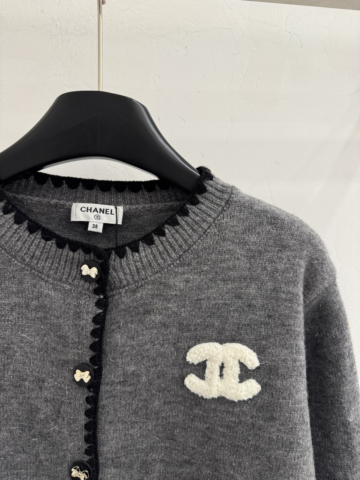 Chanel 圆领纽扣开衫‌设计，整体设计融合了品牌 元素与现代简约风格，纯色风格 简约百搭