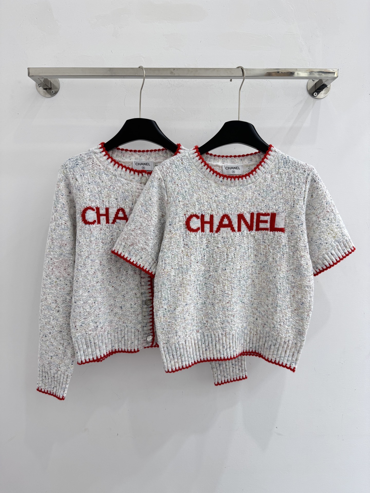 Chanel 字母针织短袖，灰白色混纺针织面料，带有细微的彩色杂点纹理，质感柔软且透气，胸前红色字母提花字体简约