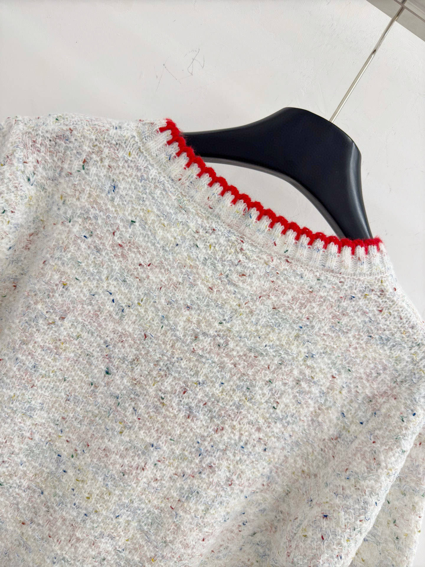 Chanel 字母针织短袖，灰白色混纺针织面料，带有细微的彩色杂点纹理，质感柔软且透气，胸前红色字母提花字体简约