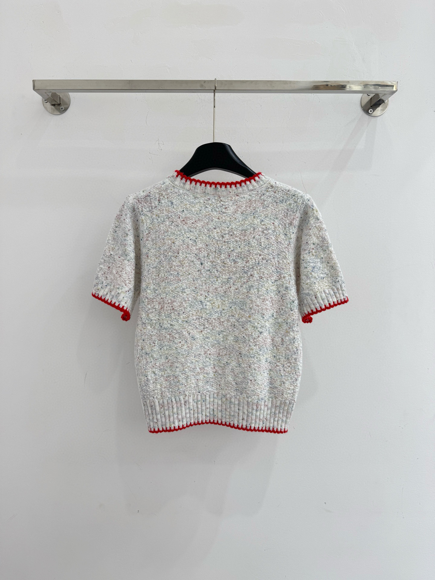 Chanel 字母针织短袖，灰白色混纺针织面料，带有细微的彩色杂点纹理，质感柔软且透气，胸前红色字母提花字体简约